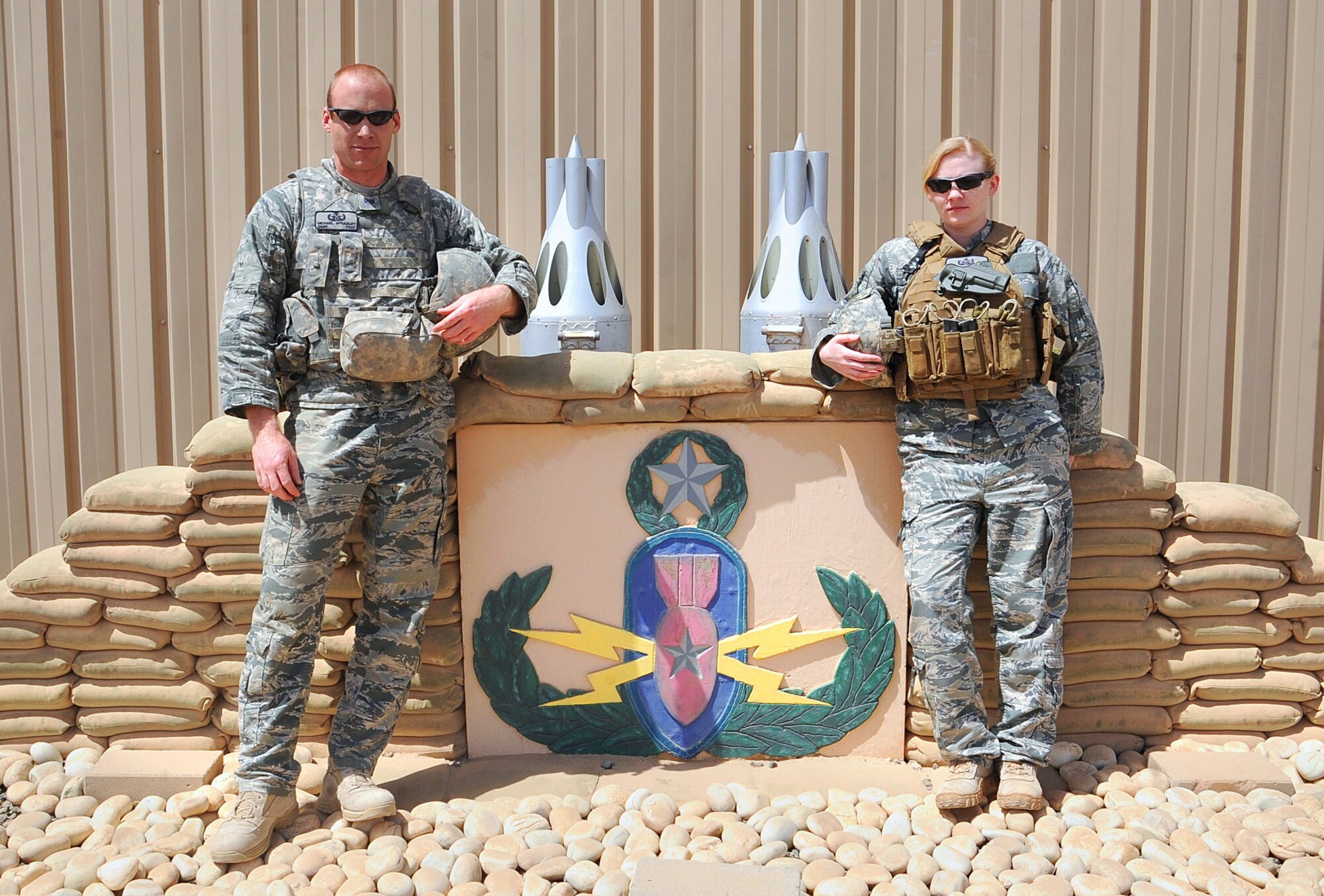 Staff Sgts. Michael Spradley and Kimberly Pate, both explosive ordnance disposal technicians with the 386th Expeditionary Civil Engineer Squadron, pose in front of their building April 16. Sergeant Spradley and Pate responded when an unexploded ordnance was found on base April 15. Sergeant Spradley is deployed from Spangdahlem Air Base in Germany and Sergeant Pate is deployed from Seymour Johnson Air Force Base, in N.C. (U.S Air Force photo by Senior Airman Cynthia Spalding)