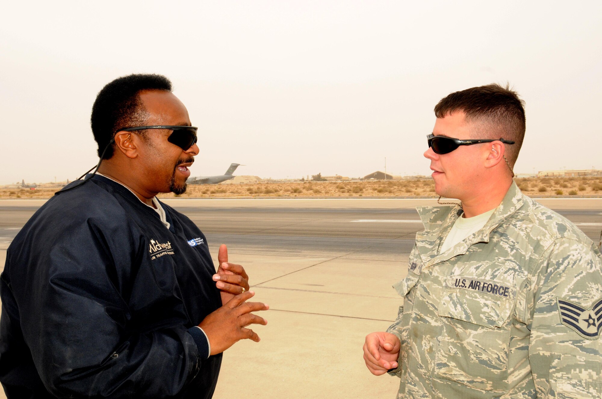 Sam Cutler, the airfield manager with the 386th Expeditionary Operations Support Squadron, talks with Staff Sgt. Mark Brisson, an engineer's assistant assigned to the 386th Expeditionary Civil Engineer Squadron, about continuing airfield construction projects. Mr. Cutler is a contractor with Midwest Air Traffic Control Service, Inc., the company who overseas the airfield management and air traffic control services at the 386th Air Expeditionary Wing. Mr. Cutler is originially from Springlake N.C., and Sergeant Brisson is a New Jersey Guardsman deployed from the 177th Civil Engineer Squadron. (U.S. Air Force photo by Staff Sgt. Patrice Clarke)