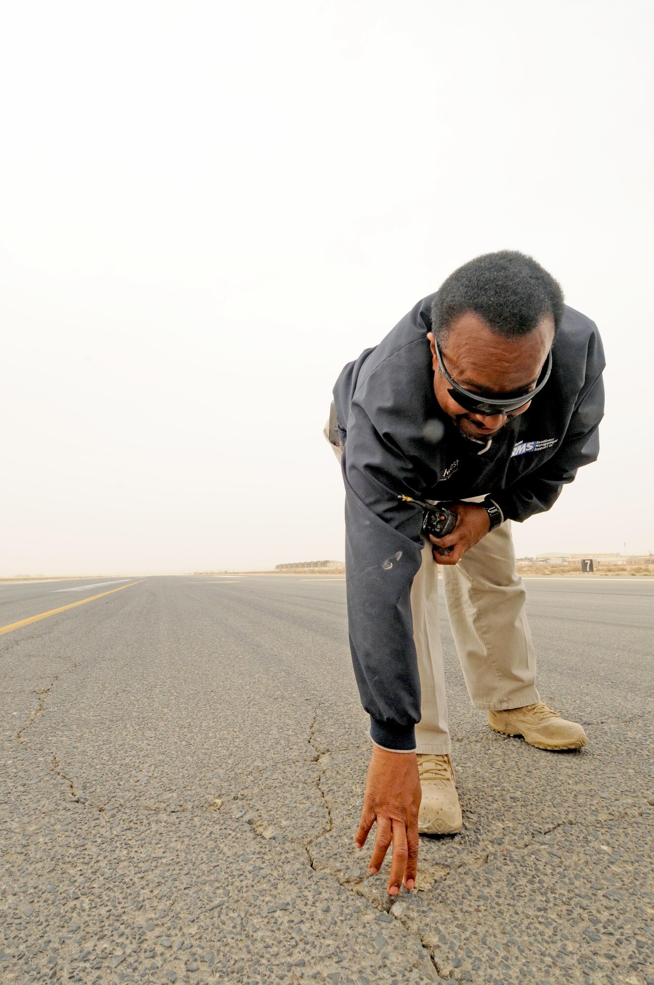 Sam Cutler, the airfield manager with the 386th Expeditionary Operations Support Squadron, checks for loose rocks in cracks on the runway here. As the airfield manager, Mr. Cutler is in charge of ensuring that the airfield is safe for aircraft and personnel. Mr. Cutler is a contractor with Midwest Air Traffic Control Service, Inc., the company who overseas the airfield management and air traffic control services at the 386th Air Expeditionary Wing. Mr. Cutler is originially from Springlake N.C. (U.S. Air Force photo by Staff Sgt. Patrice Clarke)