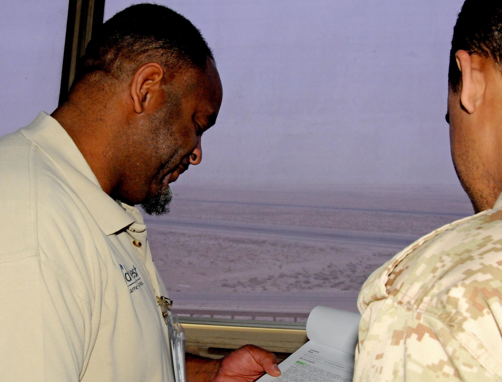 General Fail, an air traffic control liaison with the 386th Expeditionary Operations Support Squadron, goes over some safety regulations with a host nation air traffic controller. Mr. Fail is a contractor with Midwest Air Traffic Control Service, Inc., the company that currently overseas all airfield management and air traffic control services at the 386th Air Expeditionary Wing. Mr. Fail is originially from Mobile, Ala. (U.S. Air Force photo by Staff. Sgt. Patrice Clarke)
