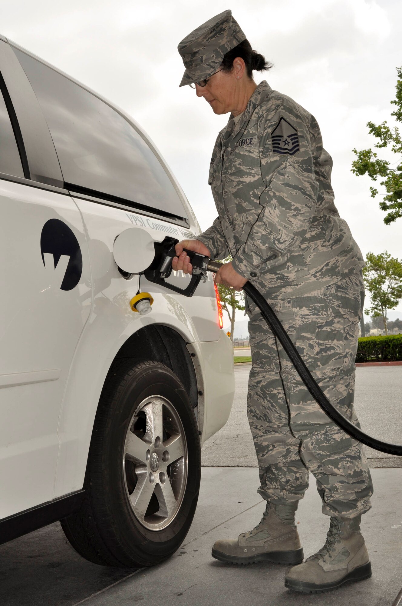 Master Sgt. Linda Welz pumps gas into a rideshare van at a gas station across the street from March Air Reserve Base, Calif., April 18, 2011.  Defense Department service members and civilian employees who use an alternate form of transportation are eligible for monthly vouchers, which, in almost all cases, cover the cost of vanpooling, including gas.  (U.S. Air Force photo/ Megan Just)