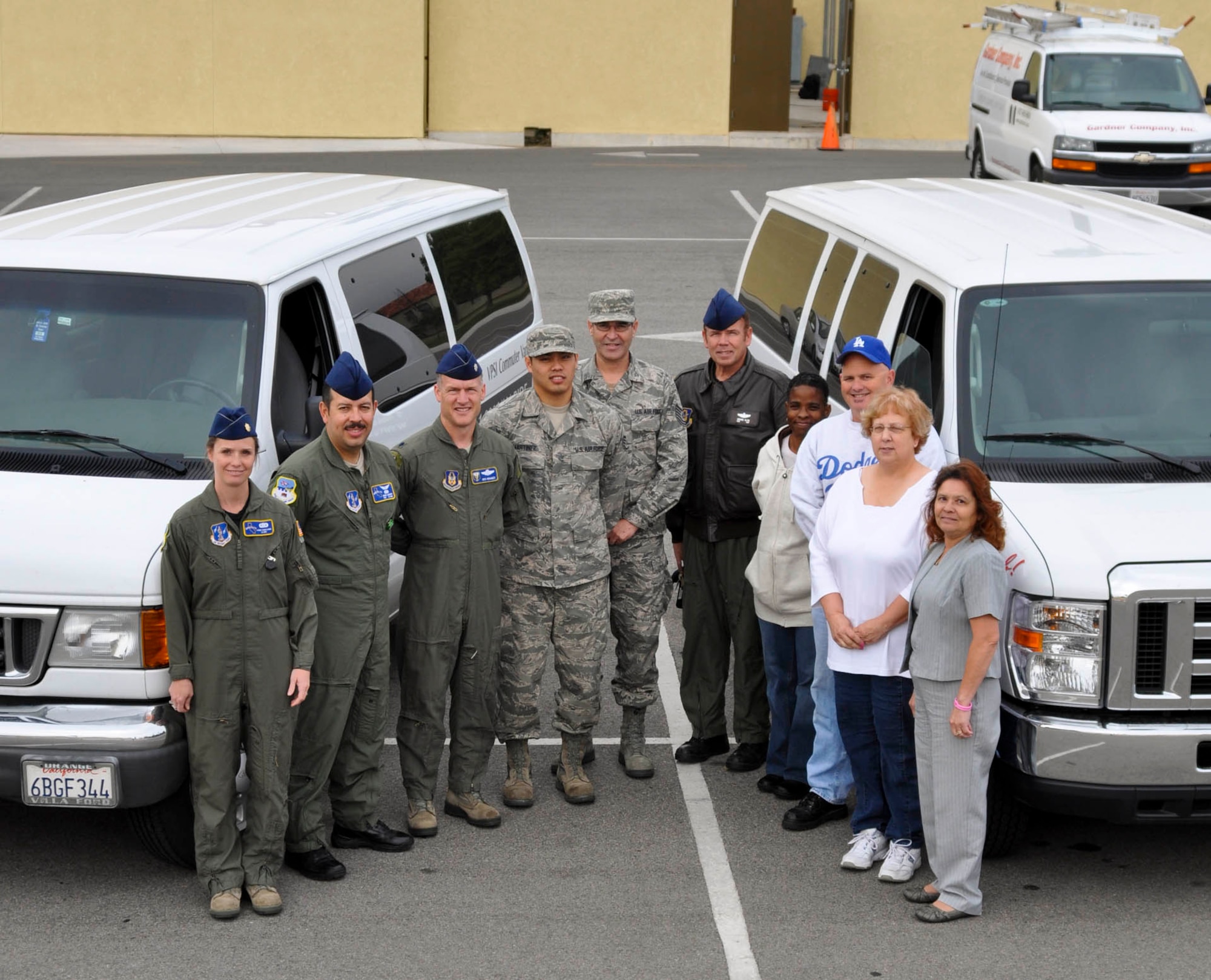 A group of vanpoolers pose with their rideshare vans at March Air Reserve Base, Calif., April 18, 2011.  More than 120 March service members and civilian employees ride in vans to work each day.  (U.S. Air Force photo/ Megan Just)