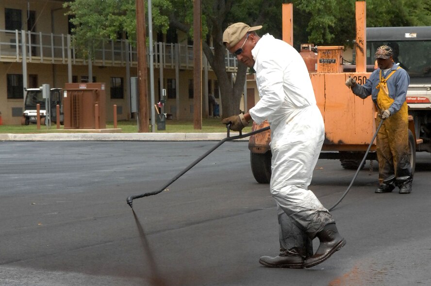 Contractors on Barksdale Air Force Base, La. work to repair a parking lot April 21, 2011. The old surface was dug up March 15 in order for the new rocks and asphalt to be laid. The new parking lot is slated to be completed April 25. (U.S. Air Force photo/Senior Airman Allison M. Boehm)(RELEASED)