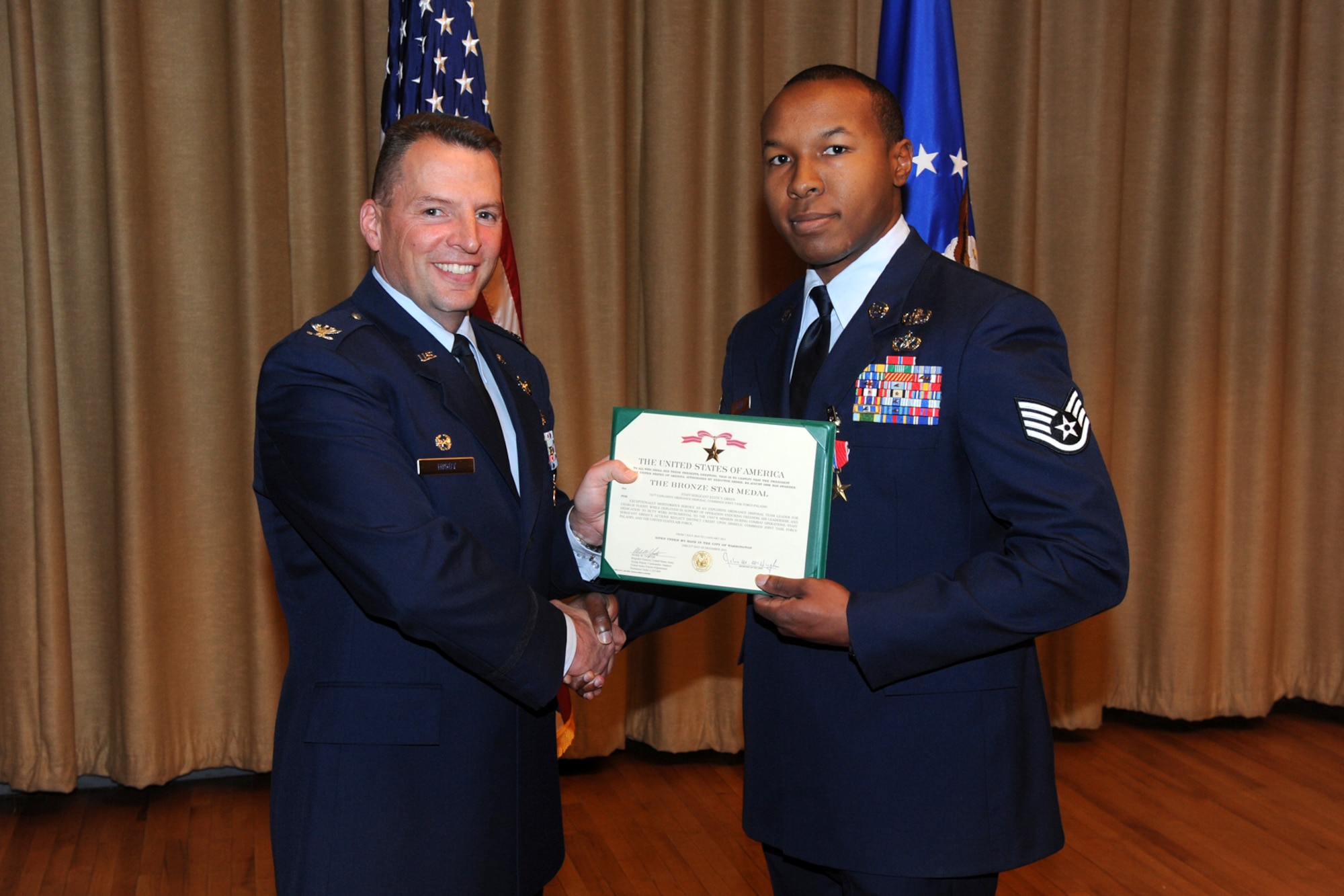 Staff Sgt. Keith Green, 775th Civil Engineer Squadron, receives his Bronze Star Medal Citation and his medal from Col. Patrick Higby, 75th Air Base Wing commander, on April 18. (U.S. Air Force photo by Alex Lloyd)