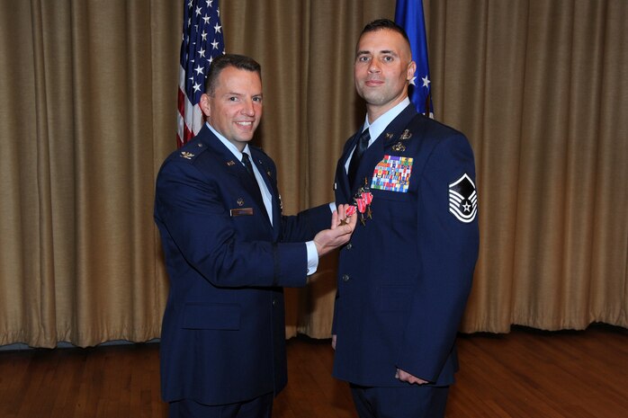 Master Sgt. Benjamin Horton, 775th Civil Engineer Squadron, receives his last Bronze Star Medal of three he received at a commander's call April 18 from Col. Patrick Higby, 75th Air Base Wing commander. He also received a Purple Heart for injuries he received. (U.S. Air Force photo by Alex Lloyd)