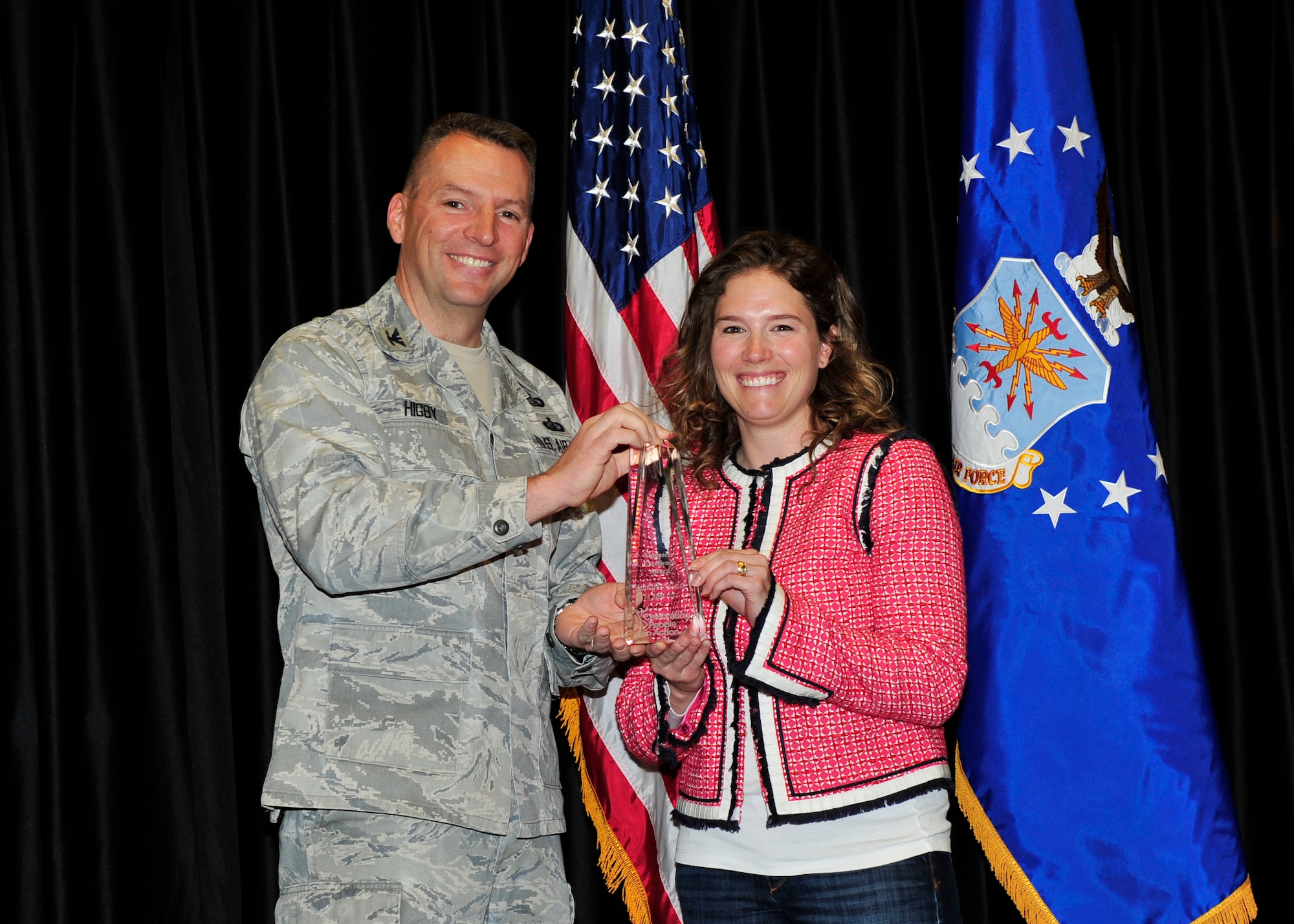 Col. Patrick Higby, 75th Air Base Wing commander, presents Jennifer Walsh, Key Spouse, 421st Fighter Squadron, with the Volunteer Excellence Award. (U.S. Air Force photo by Kim Cook)