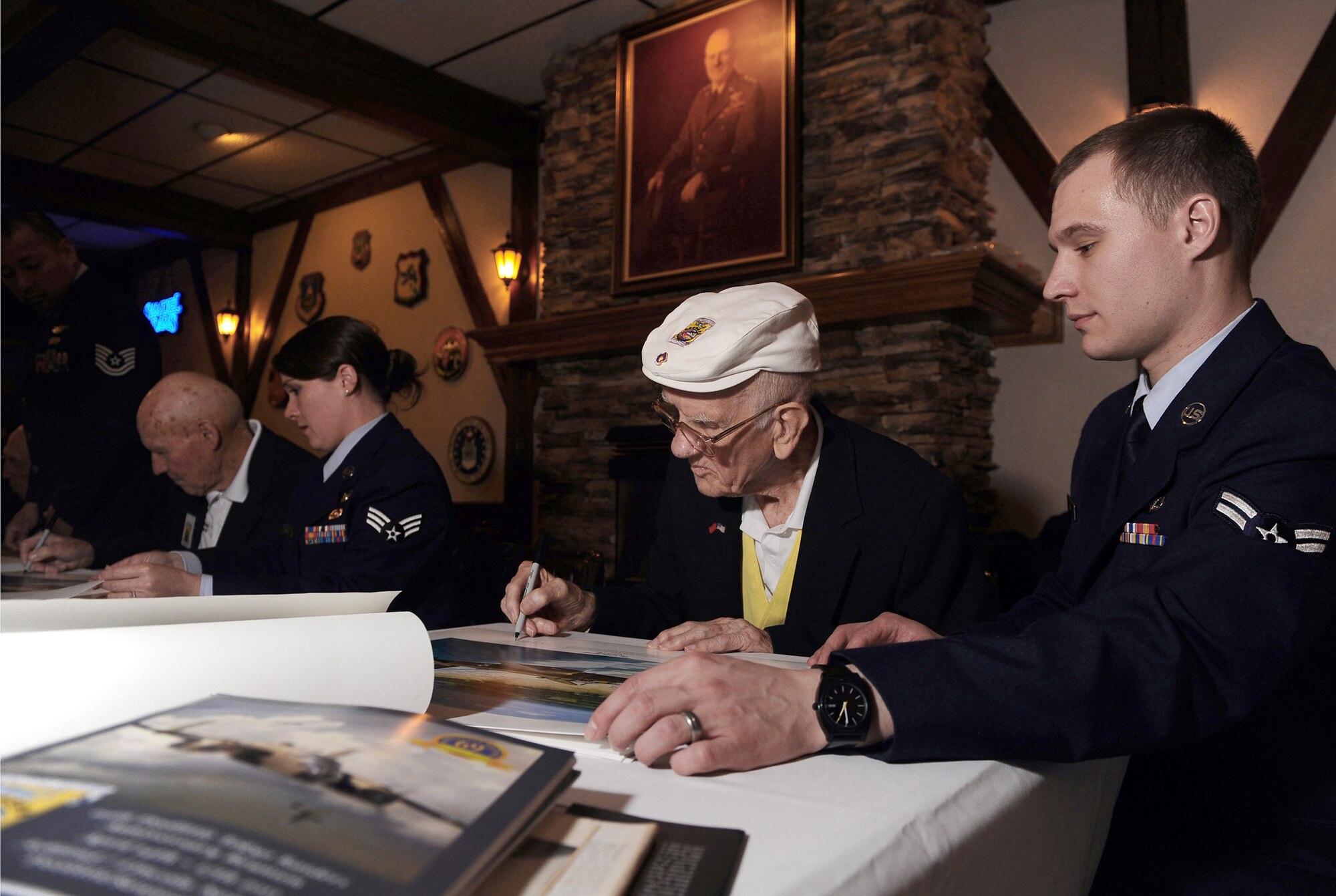 Doolittle Raider Thomas Griffin, who was a navigator on crew 9, signs autographs at the Doolittle Raiders Lounge April 15, 2011, at Offutt Air Force Base, Neb., as Airman 1st Class Paul Imm, of the 55th Operations Support Squadron, assists. The autograph session was part of the Raiders' 69th annual reunion, which took place April 14 through 17. (U.S. Air Force photo/Josh Plueger)