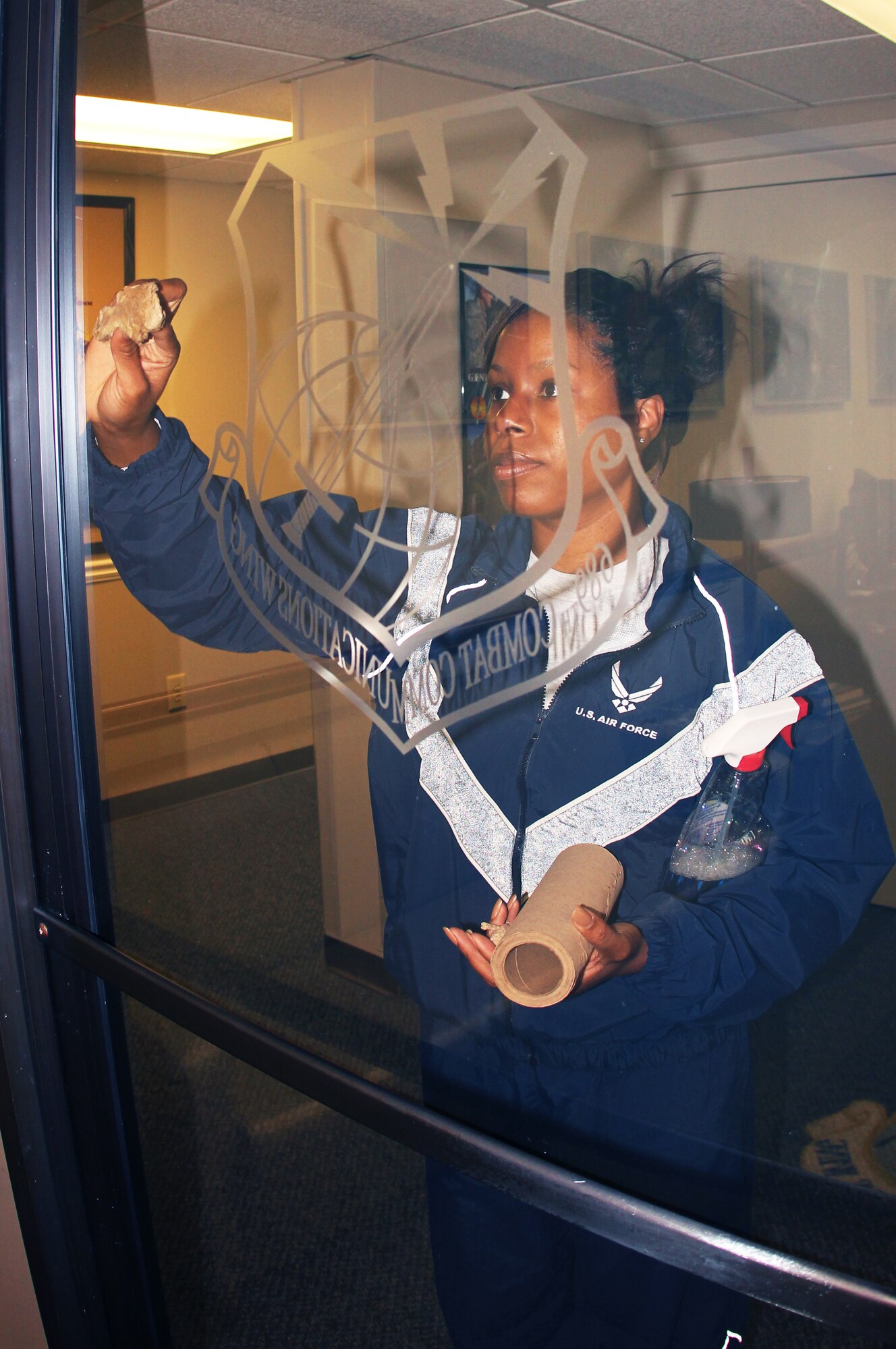 SSgt Amanda Murray, 689th Combat Communications Wing  cleans and polishes the Wing's front office door during the Base Clean-up.  The entire Wing staff was out in force clean both inside and outside of their work center. Courtesy photo