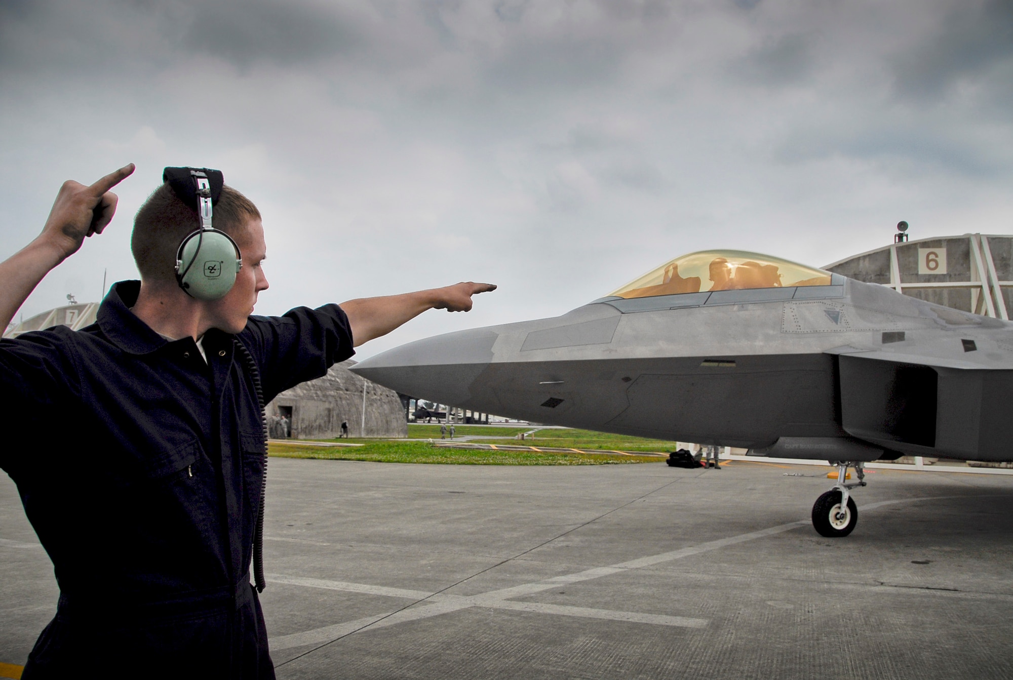 A crew chief signals the pilot of an F-22 Raptor to prepare to taxi March 31, 2011, on the flightline at Kadena Air Base, Japan. The Airmen, along with the F-22s, are assigned to the 525th Expeditionary Fighter Squadron at Joint Base Elmendorf-Richardson, Alaska. They deployed to Kadena AB earlier in 2011 to test their capabilities in a new environment and to train with Airmen and aircraft there. (U.S. Air Force photo/ Airman 1st Class Maeson L. Elleman)