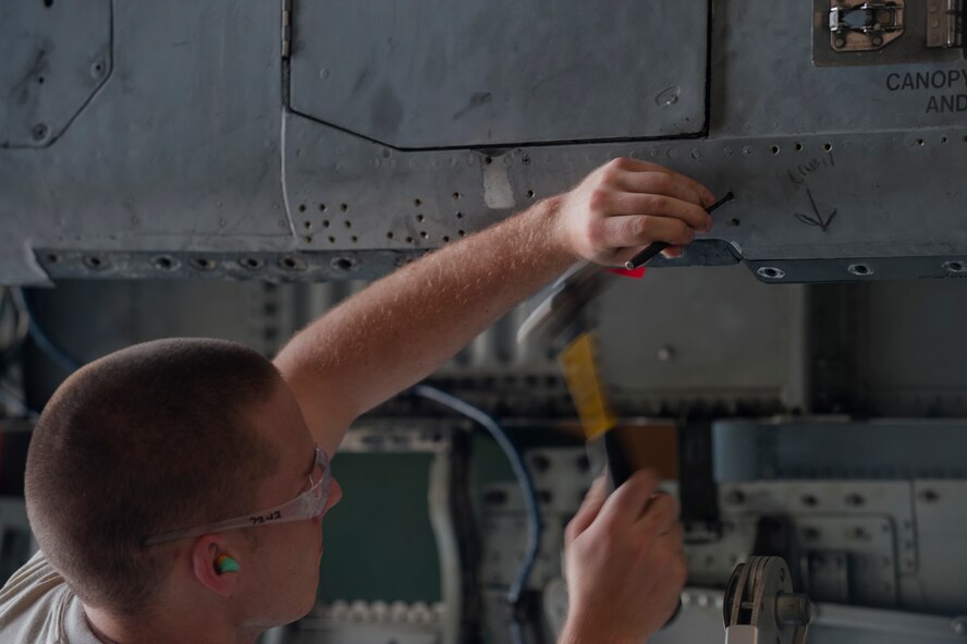Airman 1st Class Connor Minto, 23rd Equipment Maintenance Squadron aircraft structural maintenance apprentice, drives out a rivet from a panel on an A-10C Thunderbolt II at Moody Air Force Base, Ga., April 20. After all of the rivets were removed, the panel was removd. (U.S. Air Force photo/Airman 1st Class Douglas Ellis)(RELEASED)
