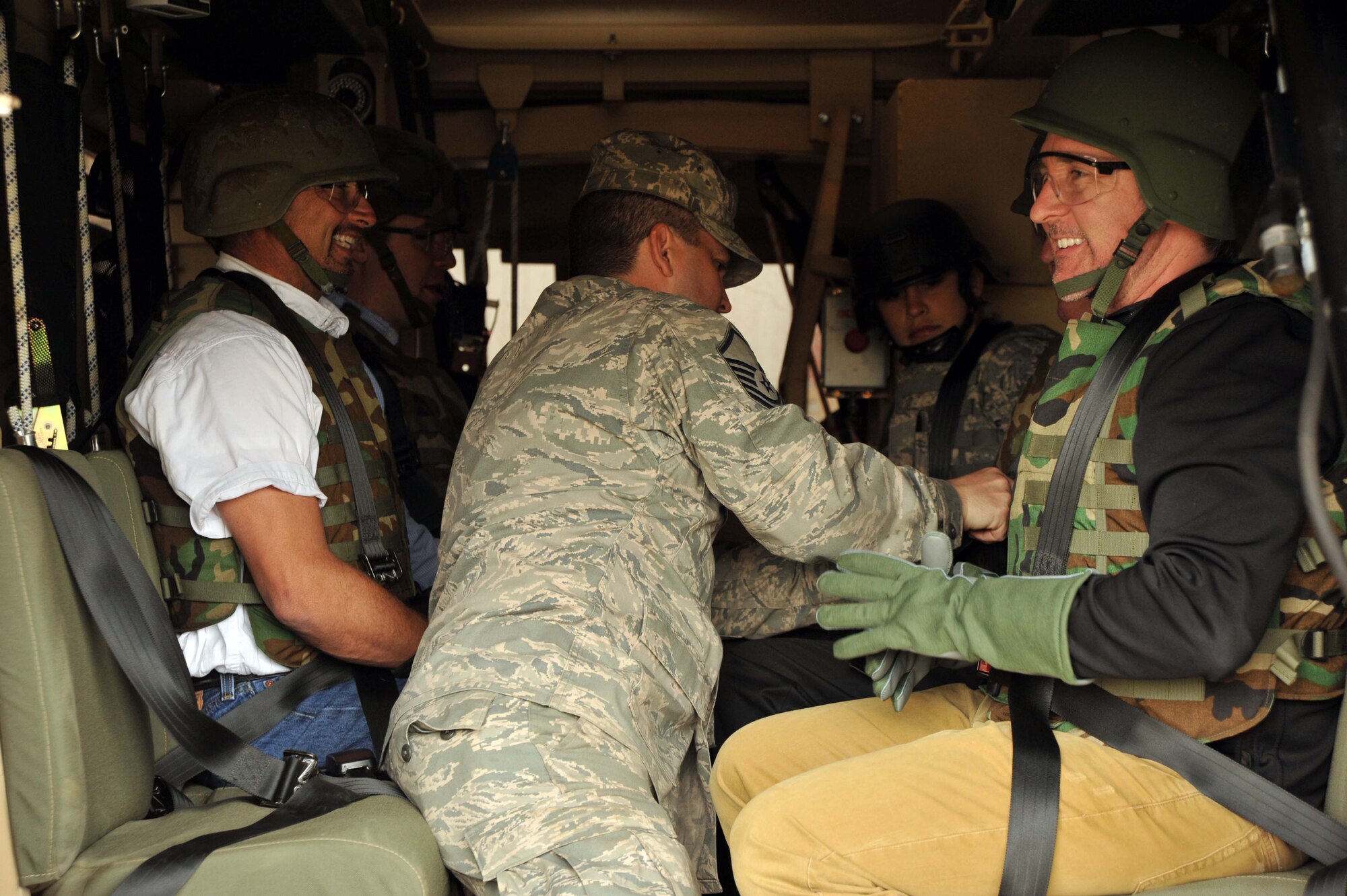 Members of McConnell's 2011 Civic Leader Tour are strapped into a Mine Resistant Ambush Protected Vehicle roll-over simulator by Tech. Sgt. Norman Ramos,421st Combat Training Squadron instructor April 20, 2011, Joint Base Mcguire-Dix-Lakehurst, N.J.  More than 20 civic leaders from Wichita, Kan., partipated in McConnell's first civic leader tour in more than five years.