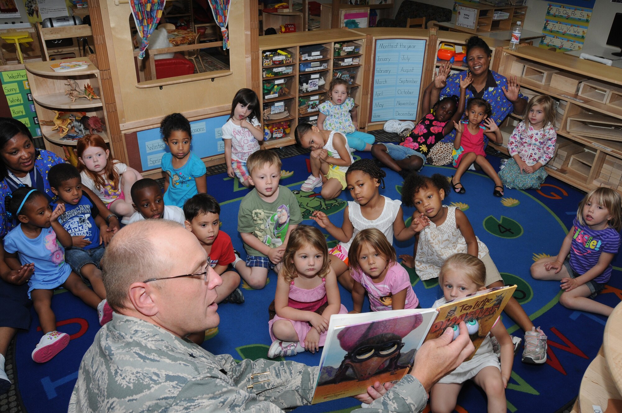 Brig. Gen. Andrew Mueller, 81st Training Wing commander, reads “10 Little Dinosaurs” to children at the child development center April 12. The special storytime is part of Keesler’s celebration of the Month of the Military Child during April.  (U.S. Air Force photo by Kemberly Groue)