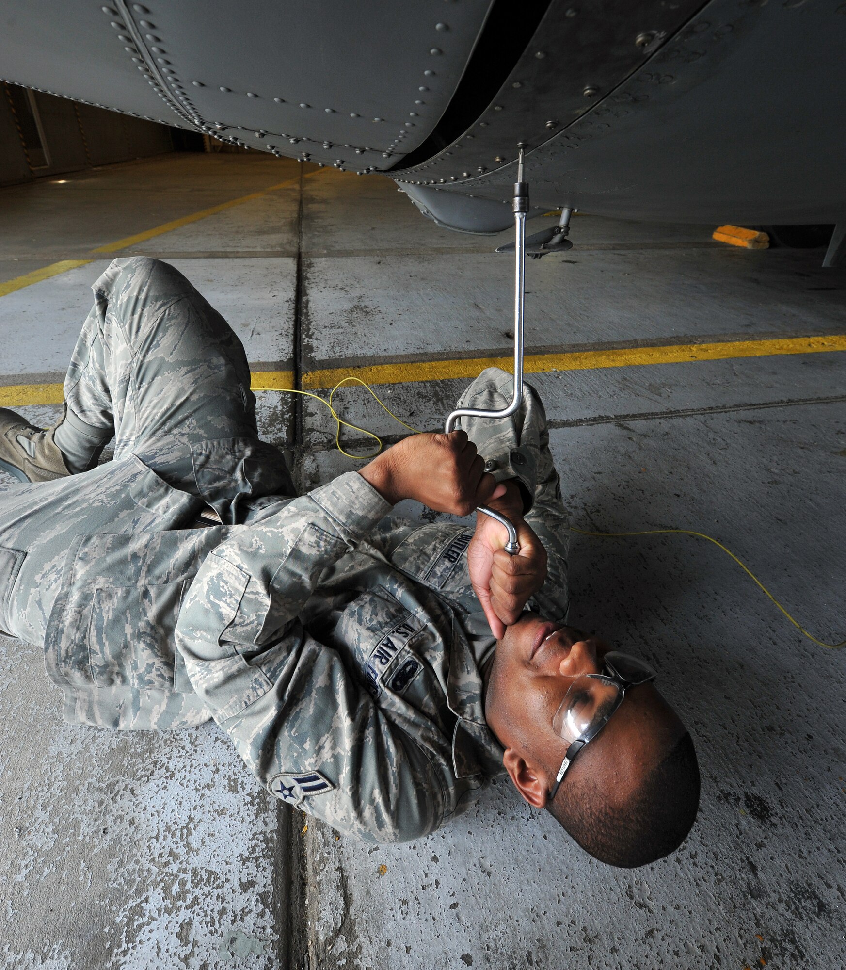 Airman 1st Class Tyler Butler, a 314th Aircraft Maintenance Squadron crew chief, tightens the bolt on a belly bank panel of a C-130 April 19, 2011, at Little Rock Air Force Base, Ark. Airmen from the 314th AMXS blue section perform maintenance on more than 30 aircraft weekly.  (U.S. Air Force photo by Staff Sgt. Chris Willis)