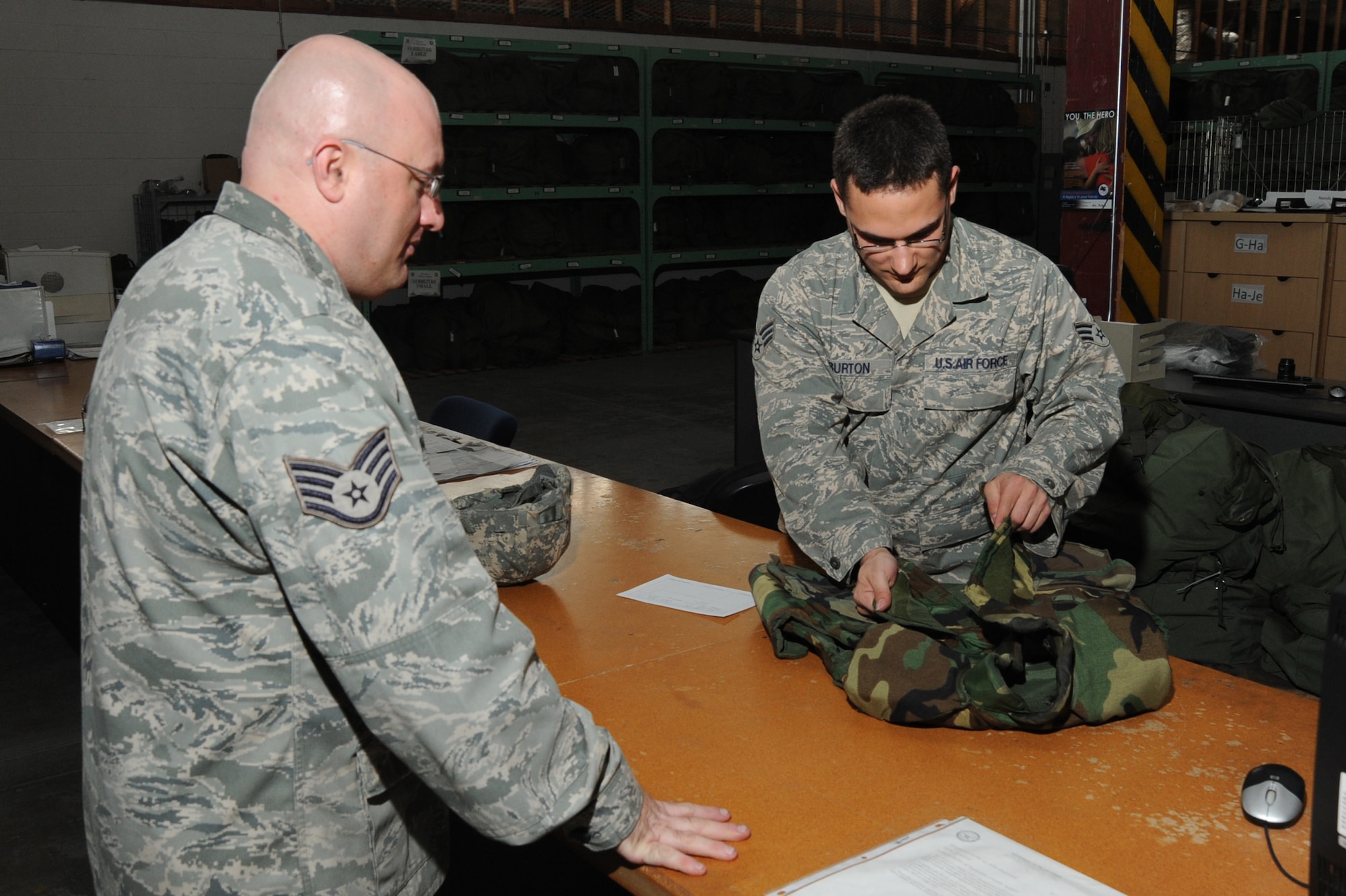 (Left to right) Staff Sgt. James Marsh, 22nd Logistics Readiness Squadron inbound supervisor, turns in previously issued body armor to Senior Airman Antonio Burton, 22nd LRS mobility technician April 19, 2011, McConnell Air Force Base, Kan. Supply personnel inspect returned items for damage and cleanliness to insure the gear is serviceable for the next individual who uses the equipment. (U.S. Air Force photo/Staff Sgt. Dallas Edwards)