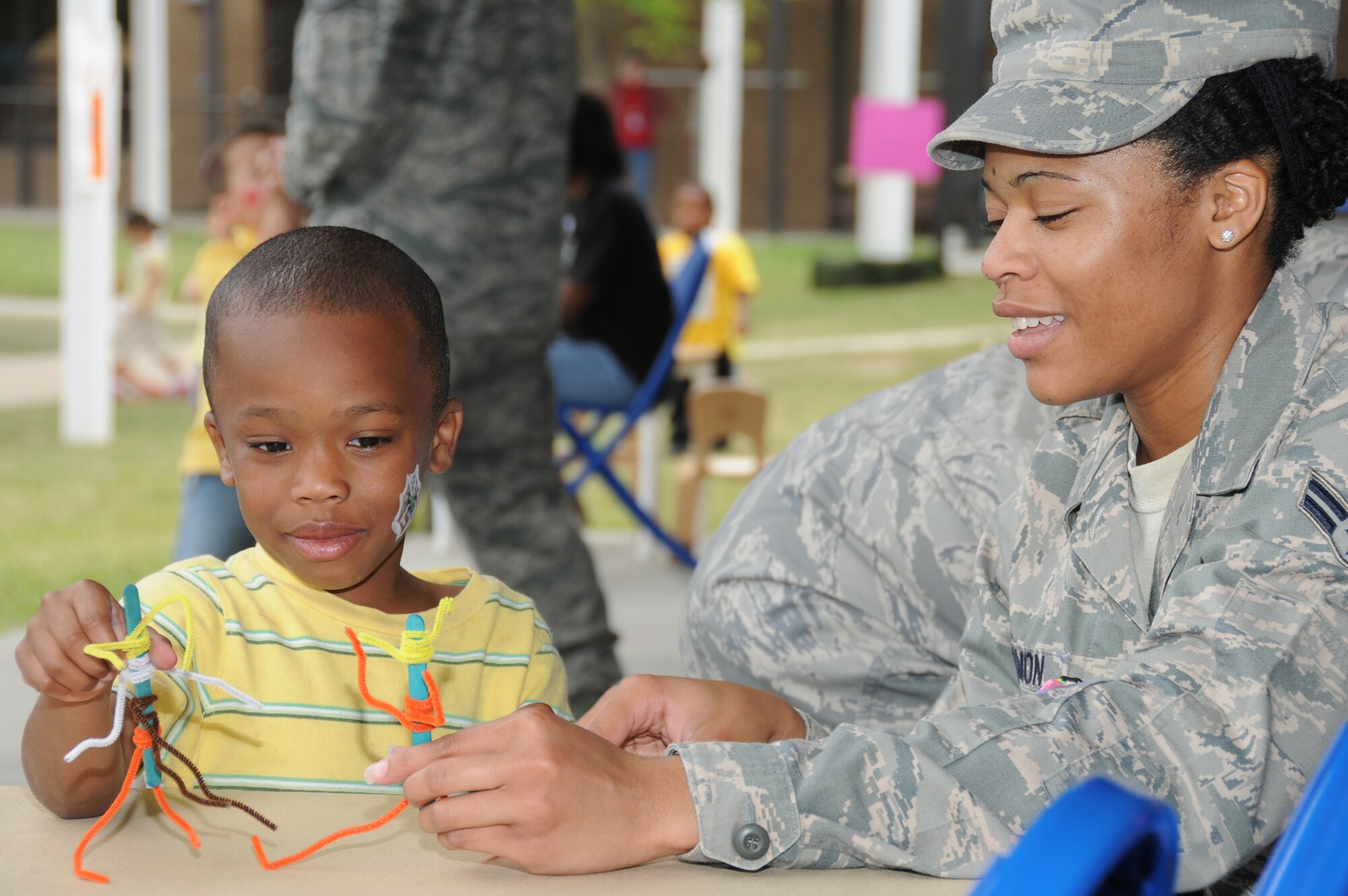 Airman 1st Class Dolores Carmon, 81st Surgical Operations Squadron, and her son Jovan Scott, 4, use pipe cleaners and popsicle sticks as the framework for their long-limbed stick figure creatures.  (U.S. Air Force photo by Kemberly Groue)