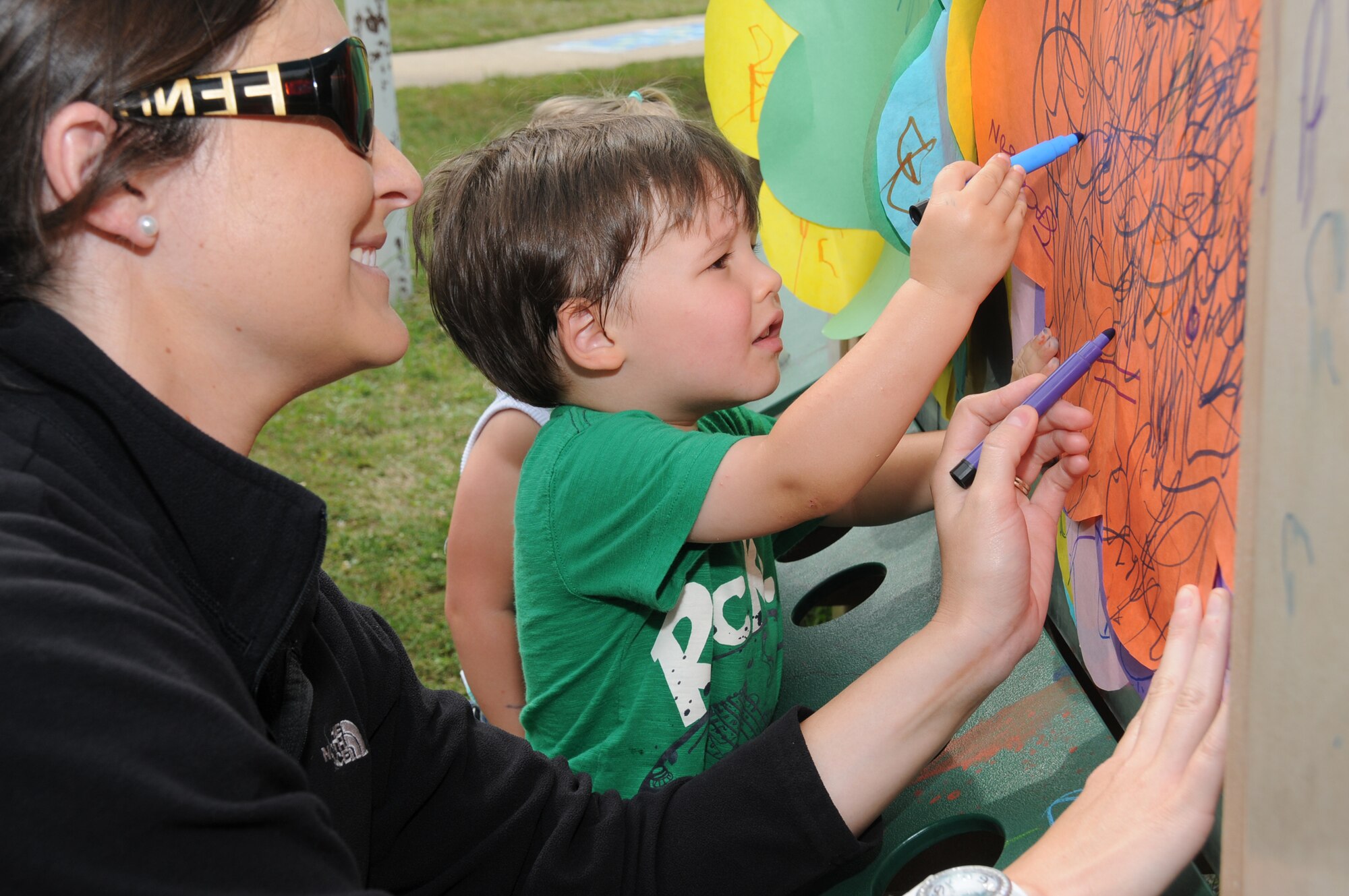 SondraWare, wife of Staff Sgt. Jason Ware, 81st Dental Squadron, and their son Jackson, 2, use colored ink on construction paper to express how much fun they are having with this abstract work of art. Art projects such as this, along with various other crafts and games, provided the backdrop for the child development center’s family
fun day, April 14.  (U.S. Air Force photo by Kemberly Groue)