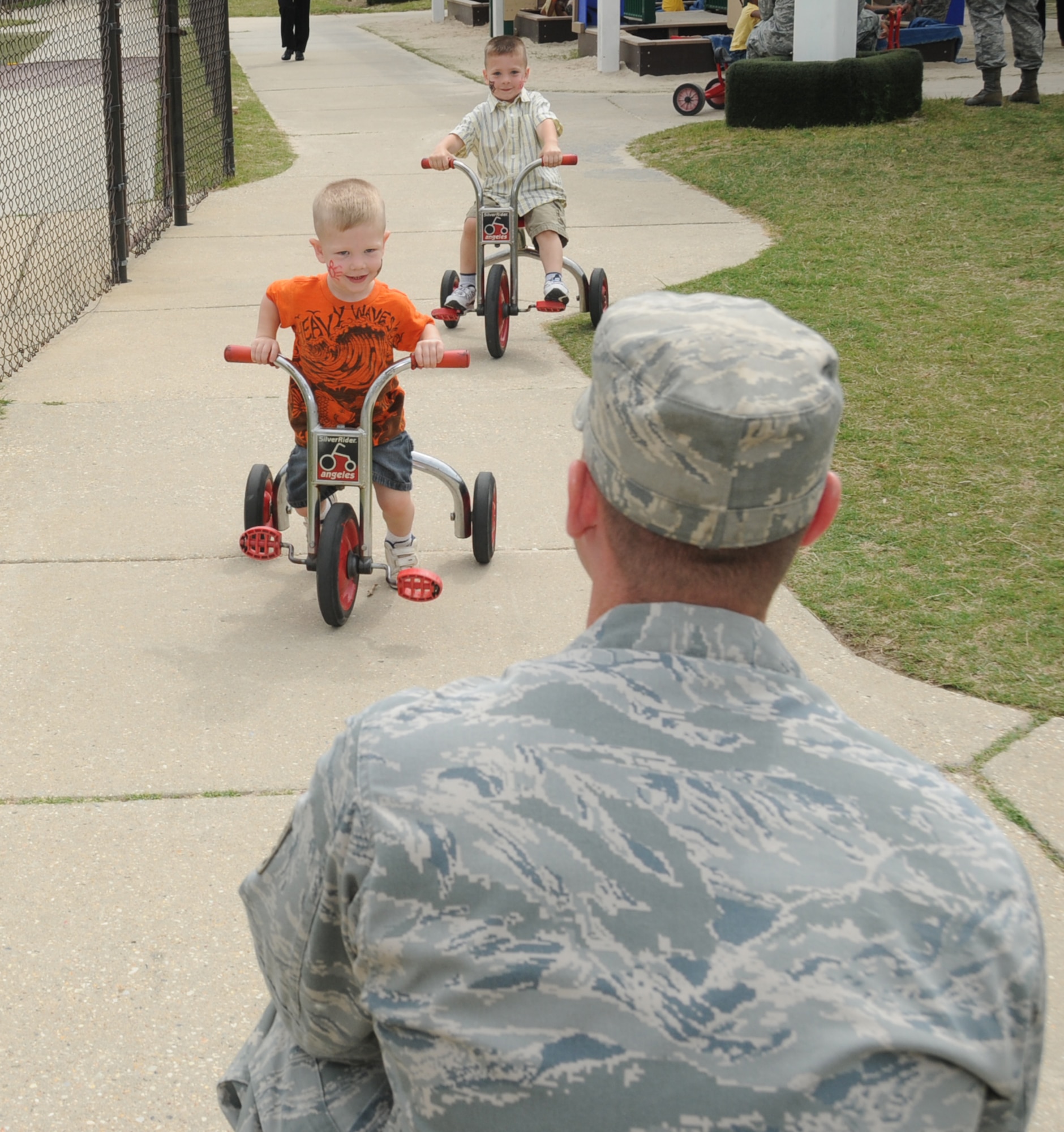 Three-year-old Brody Sigler, left, and his 4-year-old brother, Braden, race toward their
dad, Tech. Sgt. Josh Sigler, 81st Medical Group, at the child development center. Sergeant Sigler, who’s married to Johanna Sigler, is one of the parents who participated in Family Fun Day April 14. The event, part of Keesler’s Month of the Military Child observance, included a picnic, games, crafts and other activities for Keesler children and their parents.  (U.S. Air Force photo by Kemberly Groue)