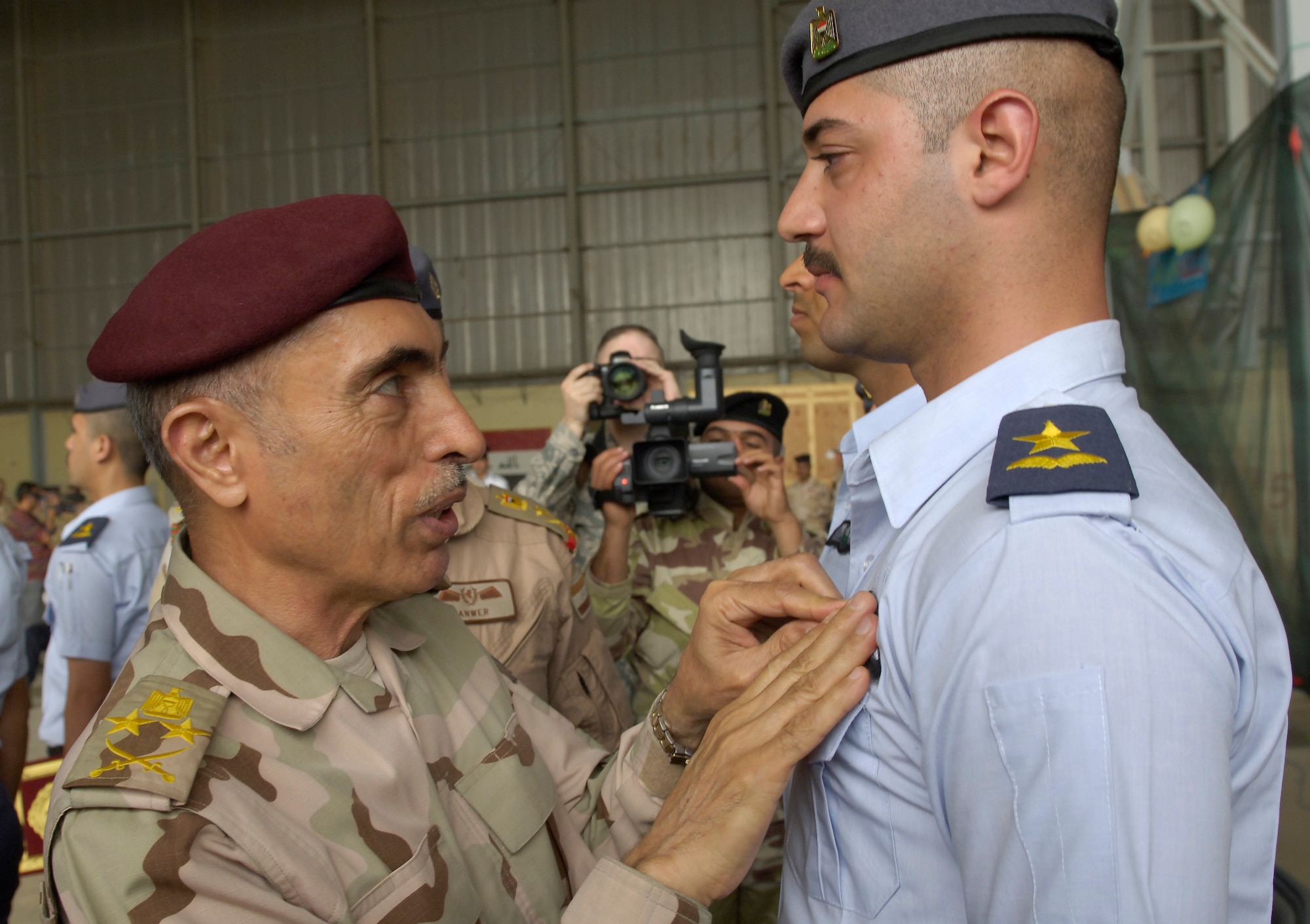 VICTORY BASE COMPLEX, Iraq – Gen. Babakir Zebari, Chief of Staff, Joint Headquarters, pins the wings on one of the newest graduates from flight training school during a ceremony April 21. The graduation ceremony was just one of many events held in celebration of the Iraqi air force’s 80th birthday. (U.S. Air Force photo by Tech. Sgt. Randy Redman) 