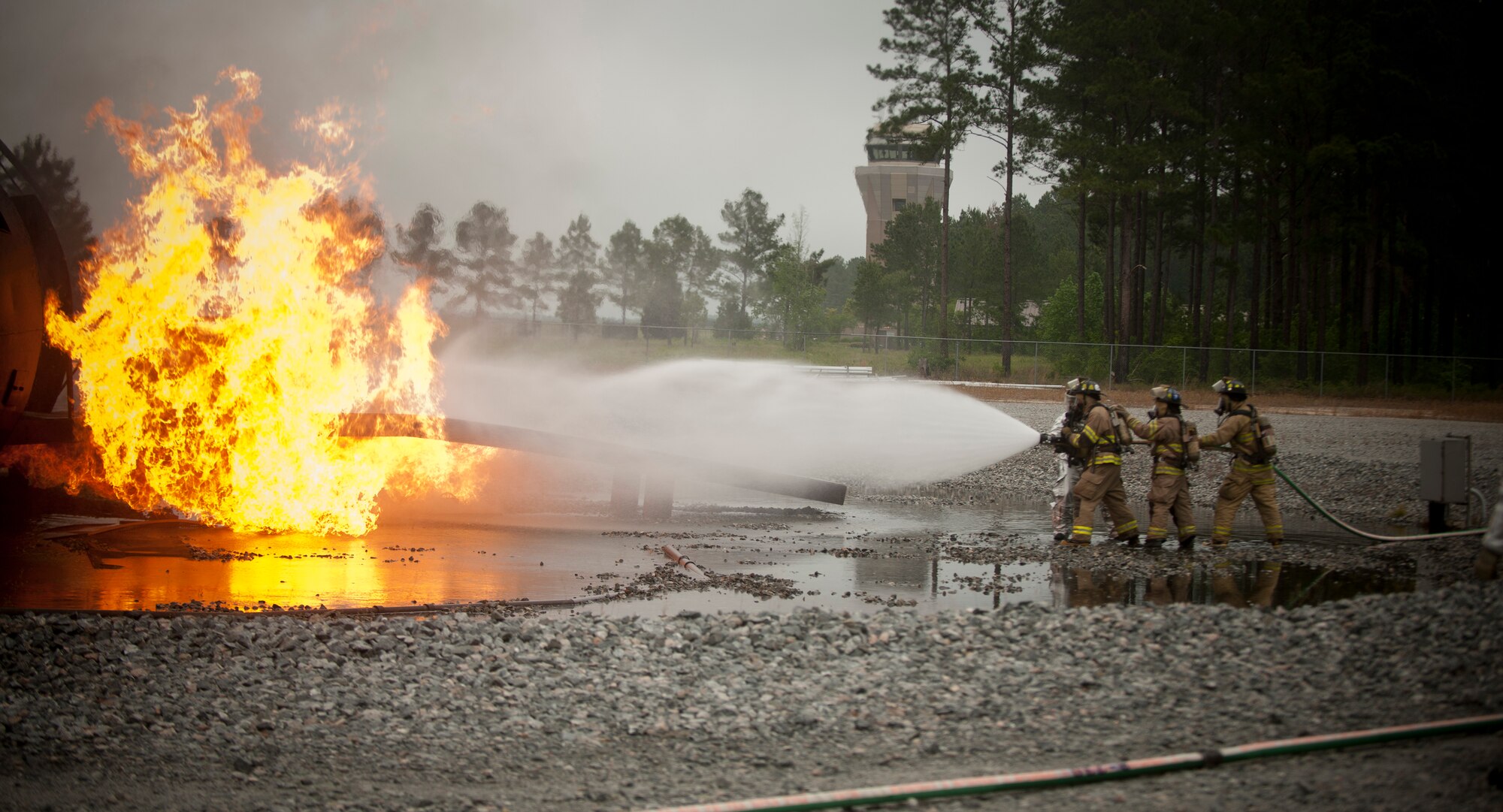 MOODY AIR FORCE BASE, Ga.-- Members of the Valdosta Fire Department attacks a ball of fire on Moody’s aircraft fire trainer during a training exercise April 20. Each individual team was tasked to put out the fire at the entry point of the aircraft and clear the interior of the aircraft of any fire. (U.S. Air Force photo/Airman 1st Class Joshua Green)(RELEASED)
