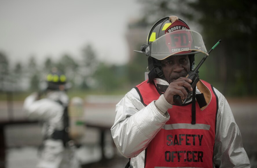 MOODY AIR FORCE BASE, Ga.-- John Miley, 23rd Civil Engineer Squadron firefighter crew chief, gives radio confirmation that all safety measures are in place during the beginning moments of a training exercise for the Valdosta Fire Department April 20. Mr. Miley will retire after 33 years of service in the military, and this was his last burn pit exercise. (U.S. Air Force photo/Airman 1st Class Joshua Green)(RELEASED)
