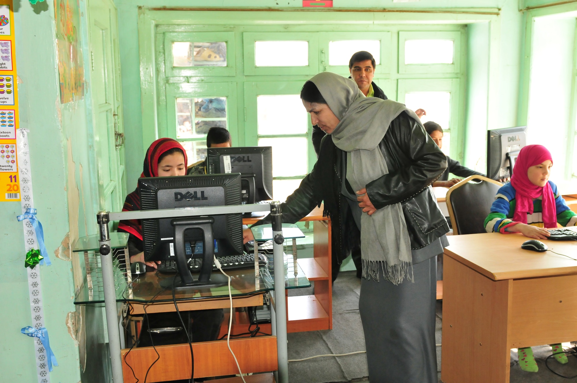 KABUL, Afghanistan -- Unidentified SOZO School teachers and students learn to use a computer. After months of coordination, computers once used in various NATO offices found their way to a school in Afghanistan. Dubbed Aladdin's Lamp, a multi-national crew from the Heavy Airlift Wing transported more than 24 computers and 130 flat screen monitors from Eindhoven, The Netherlands, to Kandahar. From there, the equipment made its way to a final destination in Kabul and were donated to SOZO, a non-profit charity organization. The computers are now in a SOZO school, where teachers educating more than 150 students. (U.S. Air Force photo/Tech. Sgt. Kevin Williams)