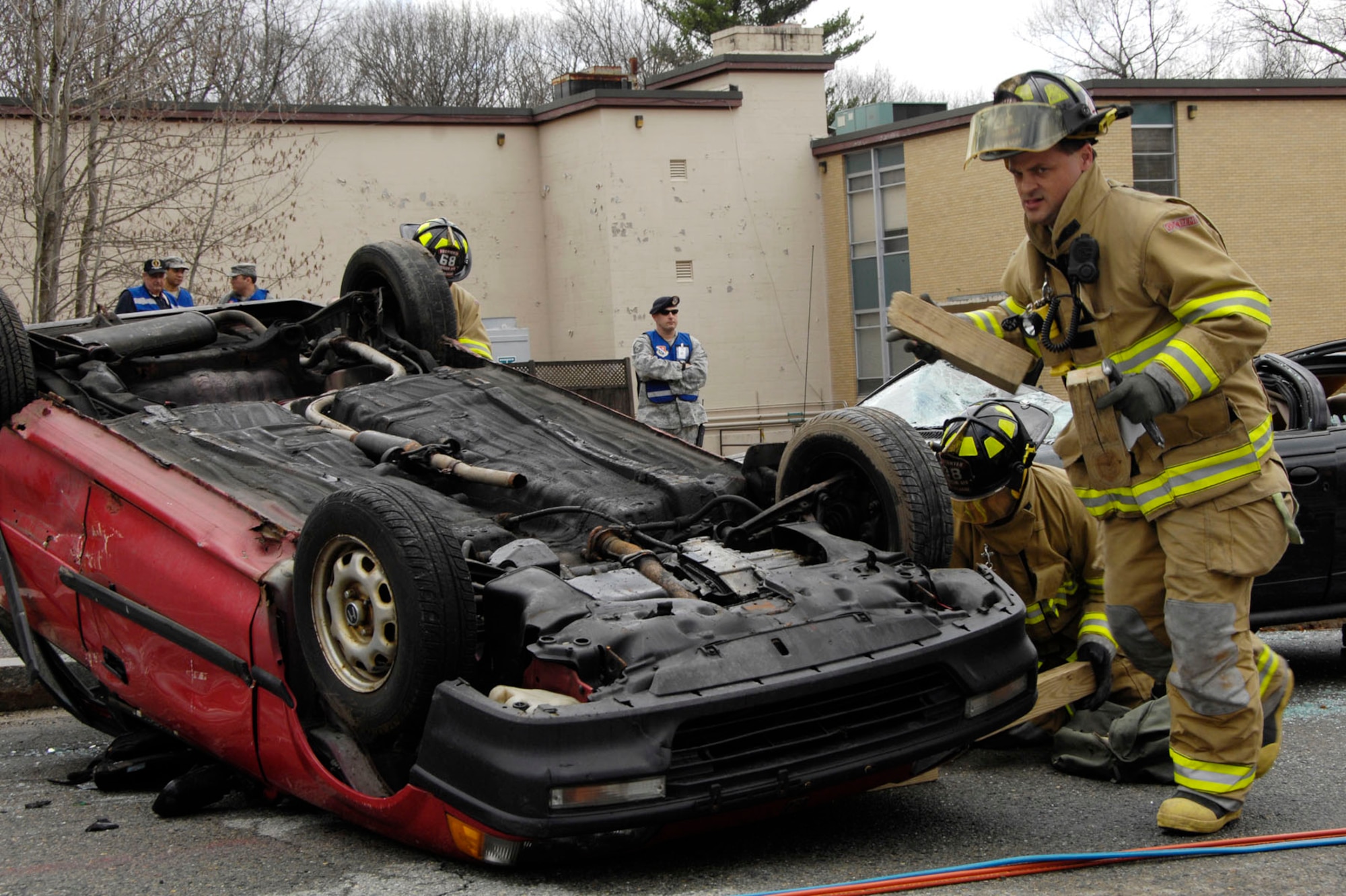 HANSCOM AIR FORCE BASE, Mass. - Todd Grierson, from the Hanscom Fire Department, works at an auto extraction scenario at the corner of Randolph Road and Tinker Loop during the Base Readiness Exercises April 14. Several exercises are planned for the next few months to prepare personnel for an impending Operational Readiness Inspection in the fall. (U.S. Air Force photo by Linda LaBonte Britt)