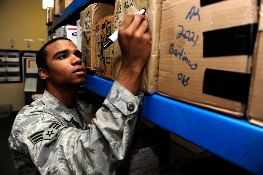 Senior Airman Curtis Robinson, 423rd Communications Squadron Postal Specialist, labels packages at RAF Alconbury, United Kingdom.  (U.S. Air Force photo by Tech. Sgt. John Barton).