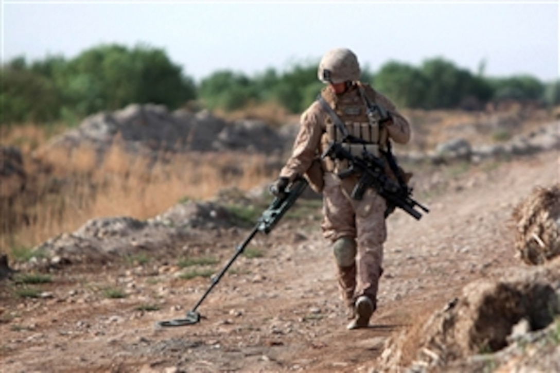 U.S. Marine Corps Lance Cpl. Jonathan Barreda uses a metal detector during a route-clearing mission near Marja in Afghanistan's Helmand province on April 9, 2011.  Barreda, a tank crewman, is assigned to the 1st Combat Engineer Battalion.  