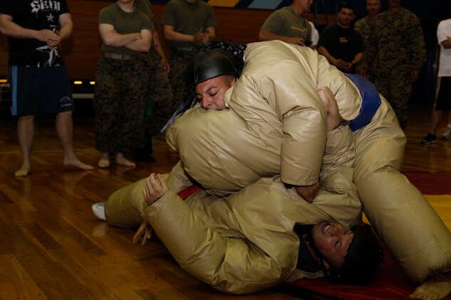 CE2 Mark R. Lahey, a Facilities competitor, throws Lance Cpl. CarlWayne J. Pecha, a Marine Aviation Logistics Squadron 12 competitor, down to the mat during the 2011 Commander’s Cup Sumo Basho at the IronWorks Gym sports courts here April 22. Five units including Marine Wing Support Squadron 171, Headquarters and Headquarters Squadron, Combat Logistics Company 36, MALS-12 and Facilities competed in the event.