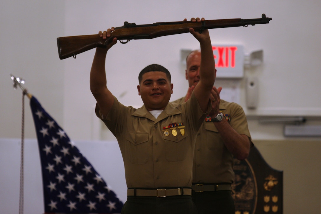 Cpl. Patrick Saleh, a shooter with the Marine Corps Shooting Team, holds up his Secretaty of the Navy award rifle in victory after winning the individual pistol portion of the 2011 Marine Corps Rifle and Pistol matches, during an awards ceremony held at the Stone Bay gymnasium aboard Marine Corps Base Camp Lejeune, April 22. The Marine Corps Matches are the culmination of the best Marine shooters from across the globe, competing against each other to determine who is the best of the best.