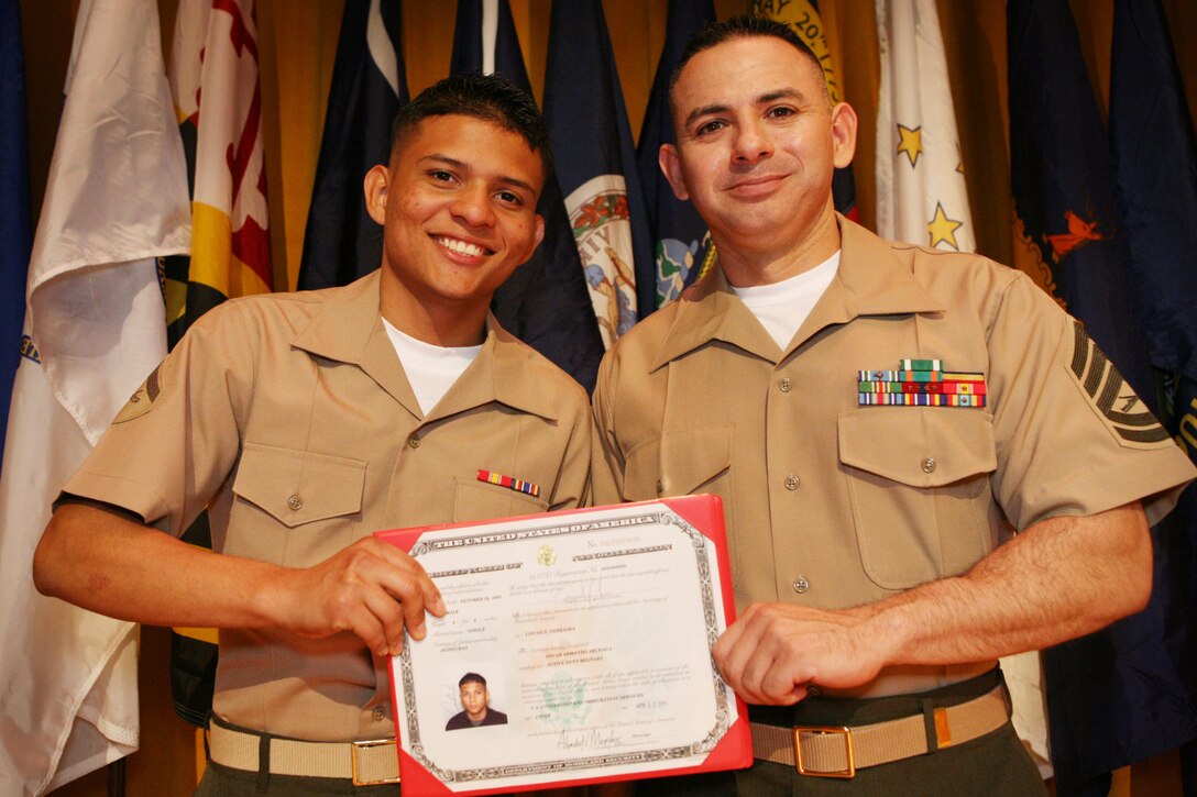 Lance Cpl. Oscar A. Archaga (left), and Gunnery Sgt. John Flores (right), both administrative specialists with the 31st Marine Expeditionary Unit, pose for a photograph after a naturalization ceremony, April 22. During the ceremony, Archaga and other service members and civilians became U.S. citizens.