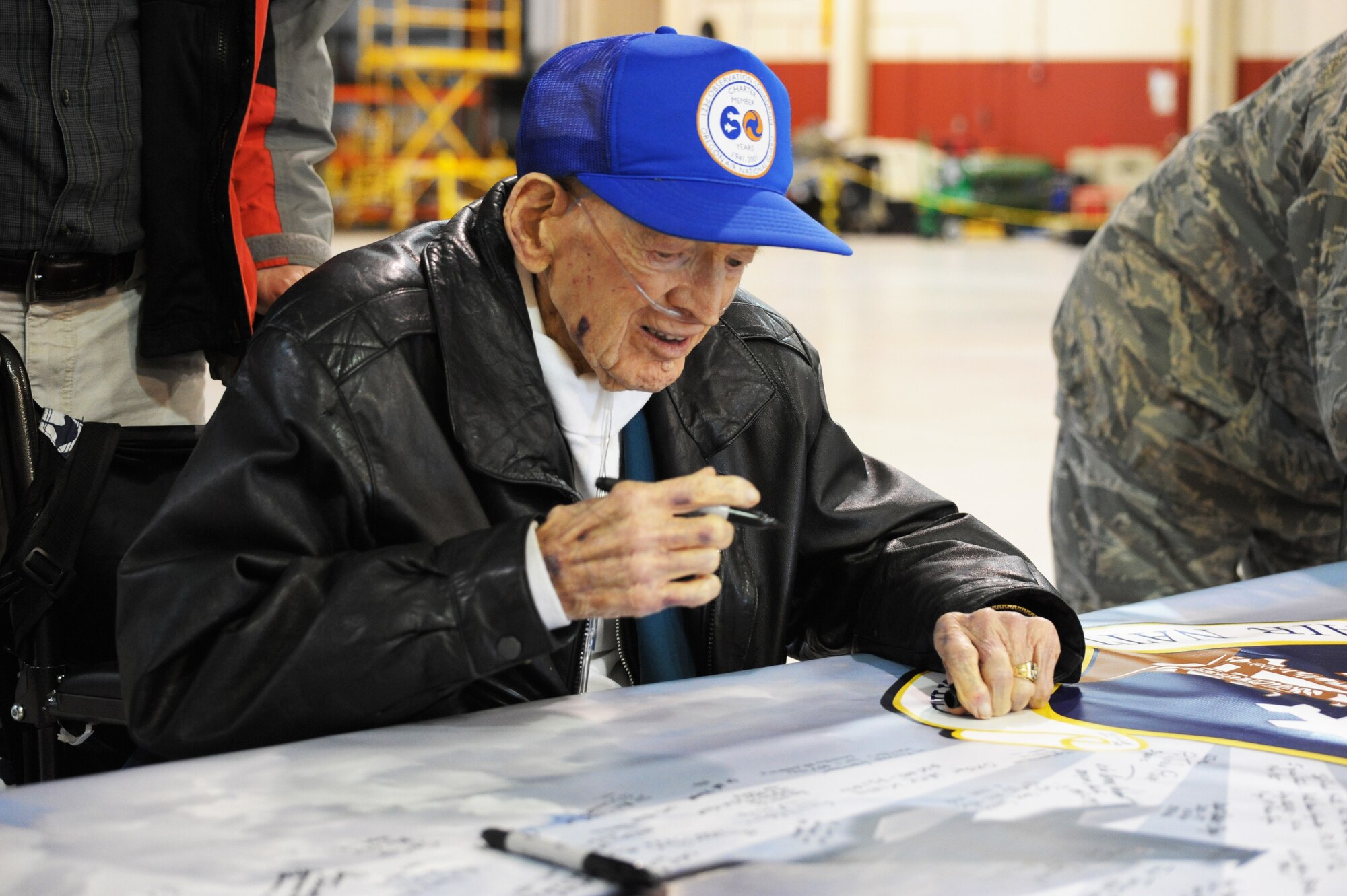 Glen Curry one of the original members of the 123rd Observation Squadron, Oregon National Guard, prepares to sign his name to the banner at the 70th Anniversary Celebration at the Portland Air National Guard Base, Portland, Ore., on April 15, 2011. (U.S. Air Force photograph by Tech. Sgt. John Hughel, 142nd Fighter Wing Public Affairs)