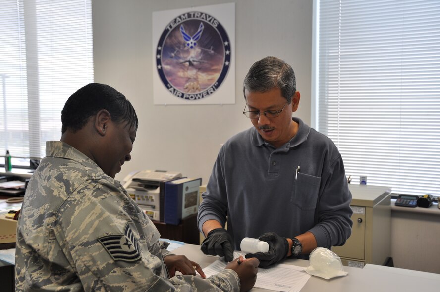 Edmund Diaz, 60th Medical Operations Squadron drug testing program administrative manager, prepares an individual for a urinalysis test April 20 at the Drug Demand Reduction Program office. (U.S. Air force photo/ 2nd Lt. Katie Batchelder) 