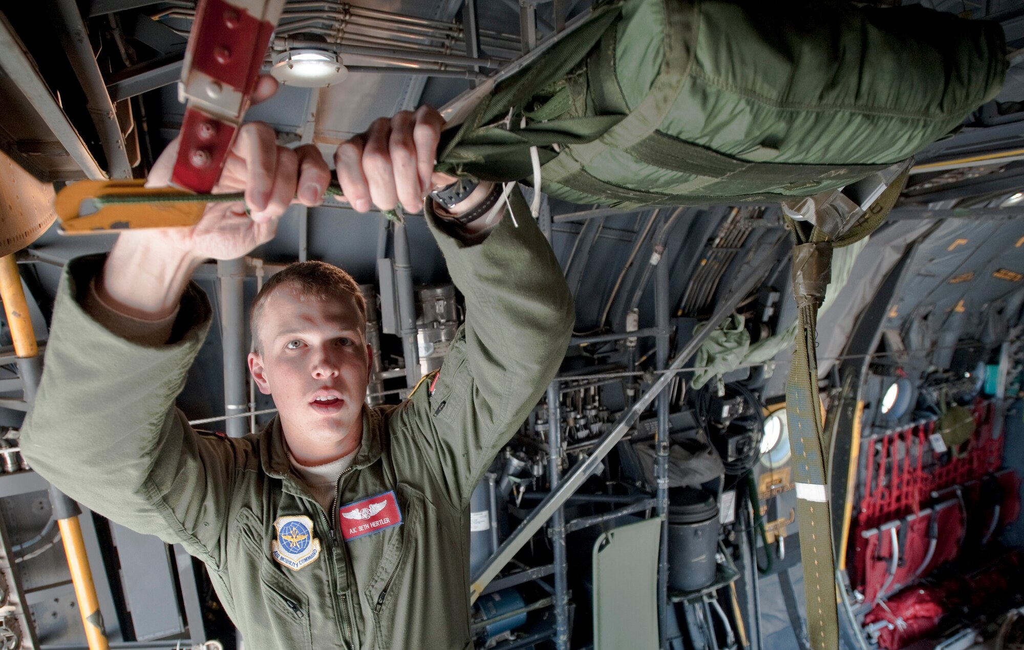JOINT BASE ELMENDORF-RICHARDSON, Alaska -- Airman 1st Class Seth Hertler, 39th Airlift Squadron, helps rig a parachute of a cargo platform to the inside of a C-130 Hercules April 18. The 39th and 40th AS's from Dyess Air Force Base, Texas have three C-130s and approximately 120 Airmen at JBER for Red Flag-Alaska.  RF-Alaska is a Pacific Air Forces-directed field training exercise for the U.S. and coalition forces flown under simulated air combat conditions. It is conducted on the Joint Pacific Alaskan Range Complex, the largest air-ground training complex in America. (Air Force photo/Senior Airman Christopher Gross)
