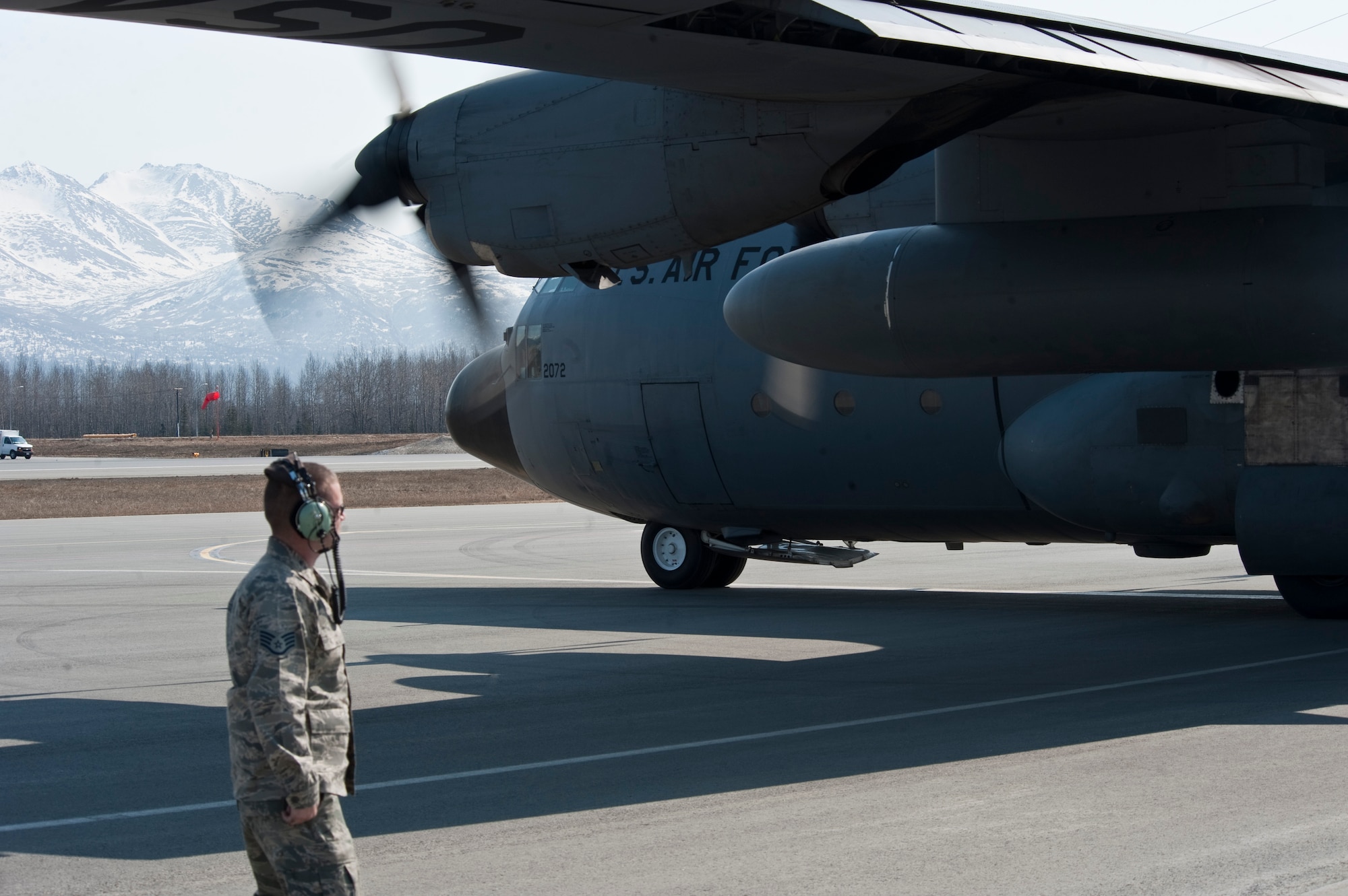 JOINT BASE ELMENDORF-RICHARDSON, Alaska --- An Airman with the 317th Aircraft Maintenance Squadron, watches a C-130 Hercules prepare to take off April 18. The 317th AMXS is part of the 39th and 40th Airlift Squadrons from Dyess Air Force Base, Texas. The squadron has three C-130s and approximately 120 Airmen at JBER for Red Flag-Alaska. RF-Alaska is a Pacific Air Forces-directed field training exercise for the U.S. and coalition forces flown under simulated air combat conditions. It is conducted on the Joint Pacific Alaskan Range Complex, the largest air-ground training complex in America. (Air Force photo/Senior Airman Christopher Gross)