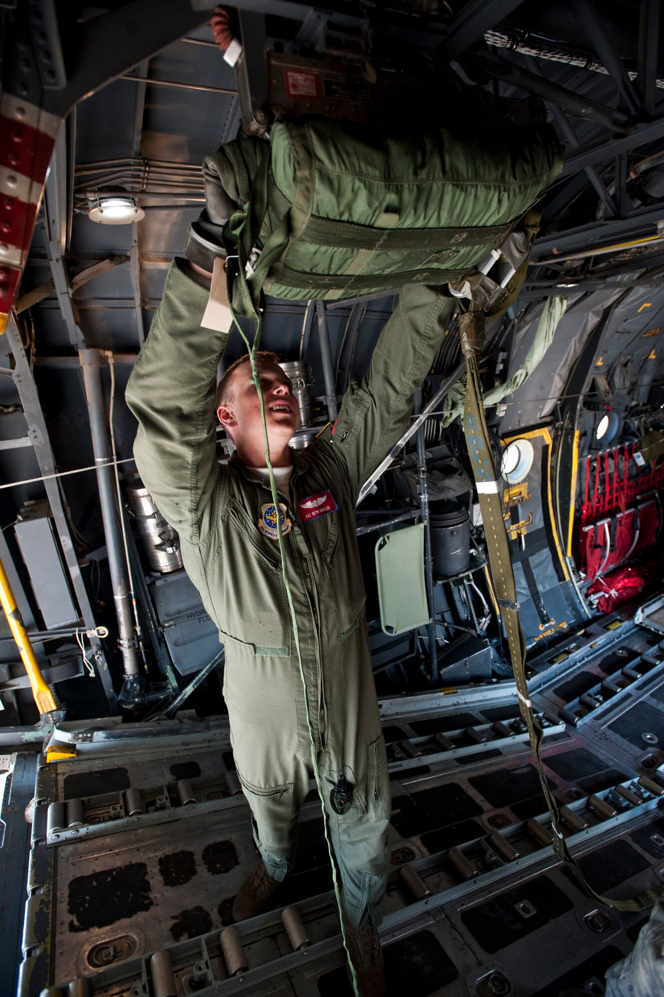 JOINT BASE ELMENDORF-RICHARDSON, Alaska -- Airman 1st Class Seth Hertler, 39th Airlift Squadron, helps rig a parachute of a cargo platform to the inside of a C-130 Hercules April 18. The 39th and 40th AS's from Dyess Air Force Base, Texas have three C-130s and approximately 120 Airmen at JBER for Red Flag-Alaska.  RF-Alaska is a Pacific Air Forces-directed field training exercise for the U.S. and coalition forces flown under simulated air combat conditions. It is conducted on the Joint Pacific Alaskan Range Complex, the largest air-ground training complex in America. (Air Force photo/Senior Airman Christopher Gross)