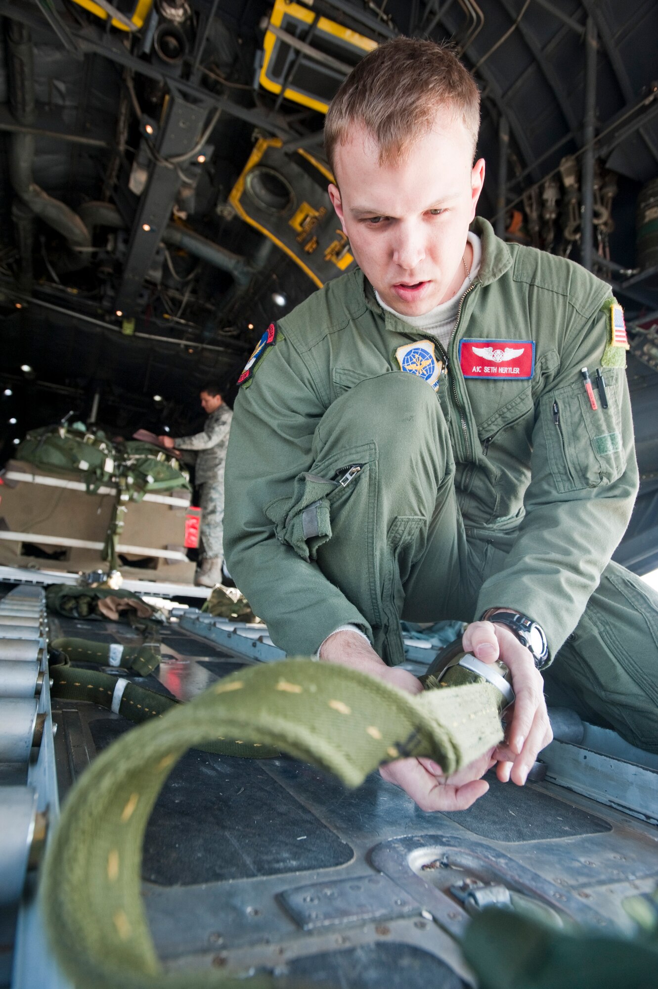 JOINT BASE ELMENDORF-RICHARDSON, Alaska -- Airman 1st Class Seth Hertler, 39th Airlift Squadron, helps rig a parachute of a cargo platform to the inside of a C-130 Hercules April 18. The 39th and 40th AS's from Dyess Air Force Base, Texas have three C-130s and approximately 120 Airmen at JBER for Red Flag-Alaska.  RF-Alaska is a Pacific Air Forces-directed field training exercise for the U.S. and coalition forces flown under simulated air combat conditions. It is conducted on the Joint Pacific Alaskan Range Complex, the largest air-ground training complex in America. (Air Force photo/Senior Airman Christopher Gross)