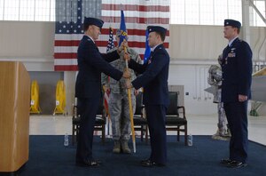 Col. Richard Boutwell, 1st Operations Group commander, presents the guidon to Lt. Col. Alan Edwards, 1st Operations Support Squadron commander, during the 1 OSS change of command ceremony in the 27th Fighter Squadron hangar at Langley Air Force Base, Va., April 15. Colonel Edwards assumed command of the squadron from Lt. Col. Thomas Shank. (U.S. Air Force photo/Airman 1st Class Jason J. Brown/Released)