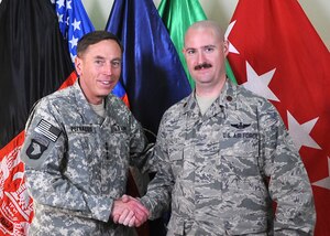 Maj. Warren Rohfls (right) shakes hands with Army Gen. David Petraeus, International Security Assistance Force commander, while deployed to Afghanistan in 2010. Major Rohlfs is deployed to Headquarters ISAF from Headquarters Air Combat Command, serving as the Military Assistant to the ISAF Director of Development. (Courtesy photo)