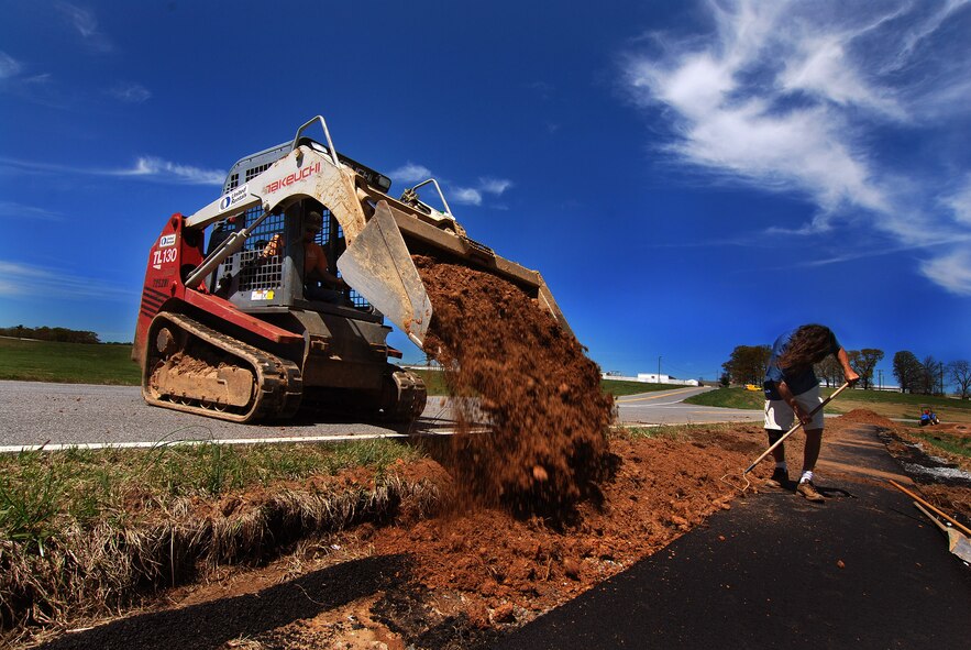 Cole Ivey dumps a load of backfill dirt while Ricky Vance spreads it evenly to finish the new west side jogging path on Dobbins Air Reserve Base, Apr 6.  The jogging path is being constructed after several years of planning to connect the Conner's Way trail running from lodging to the B.X. with the Navy path originating from the south side gymnasium so Army Guard soldiers can safely run to that gym.  Soon anyone with base access can run or stroll safely and uninterrupted, from the Dobbins lodging facility all the way to the former Navy gym located on the southwest side of the runway.  (U.S. Air Force photo/ Brad Fallin)