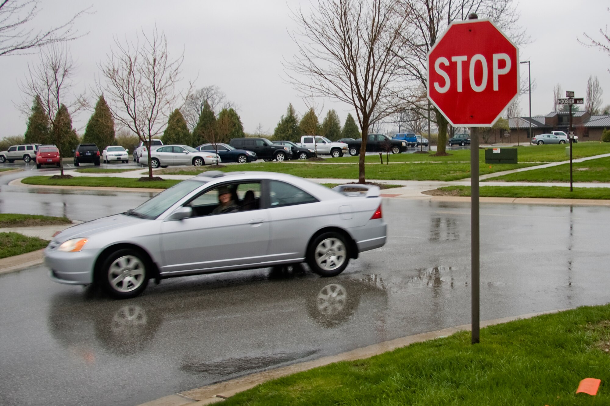 GRISSOM AIR RESERVE BASE, Ind. -- Senior Airman Michaela McClintock, 434th Logistics Readiness Squadron knowledge operations apprentice, drives by a new stop sign recently installed on base. New stop signs and crosswalk markings are being installed and speed limits are being changed across the base to better improve pedestrian safety. (U.S. Air Force photo/Tech.  Sgt. Mark R. W. Orders-Woempner)
