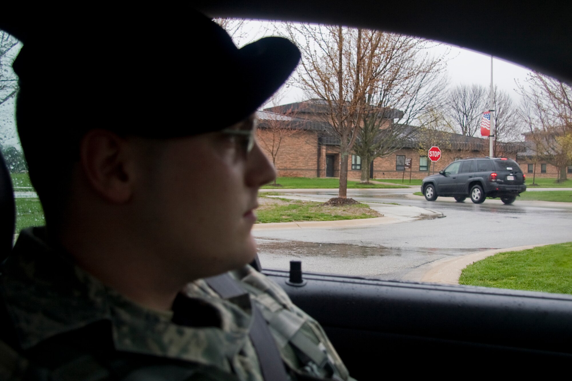 GRISSOM AIR RESERVE BASE, Ind. -- Staff Sgt. Patrick Barringer, 434th Security Forces fire team member, watches a vehicle come to a complete stop at a new stop sign recently installed on base. New stop signs and crosswalk markings are being installed and speed limits are being changed across the base to better improve pedestrian safety. Sergeant Barringer and his police car parked near the new stop sign help alert motorists to the changes. (U.S. Air Force photo/Tech.  Sgt. Mark R. W. Orders-Woempner)
