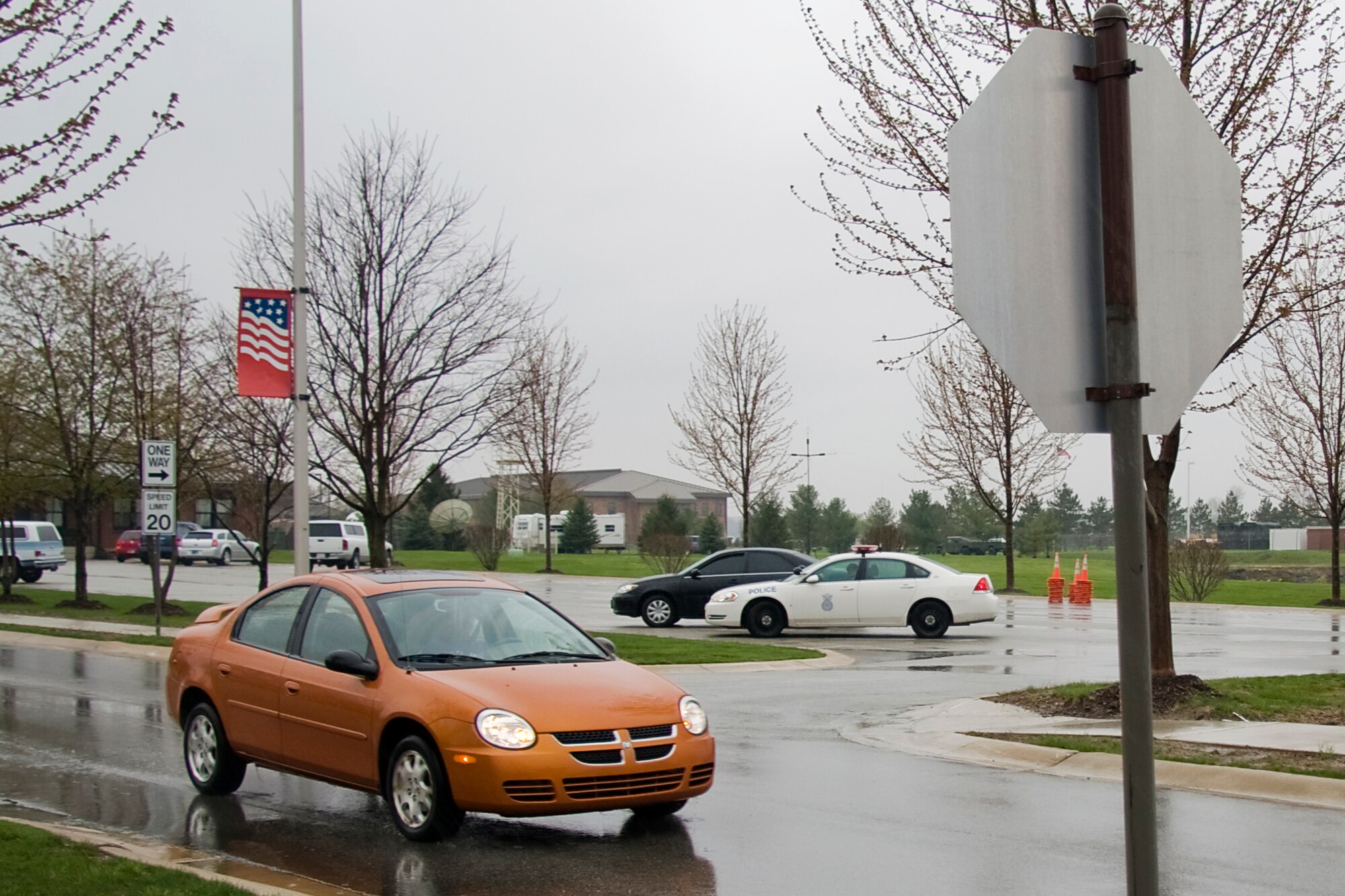 GRISSOM AIR RESERVE BASE, Ind. -- A motorist heads towards a newly installed stop sign on Skytrain Street here April 22 as Staff Sgt. Patrick Barringer, 434th Security Forces fire team member, watches. New stop signs and crosswalk markings are being installed and speed limits are being changed across the base to better improve pedestrian safety. Sergeant Barringer and his police car parked near the new stop sign help alert motorists to the changes. (U.S. Air Force photo/Tech.  Sgt. Mark R. W. Orders-Woempner)
