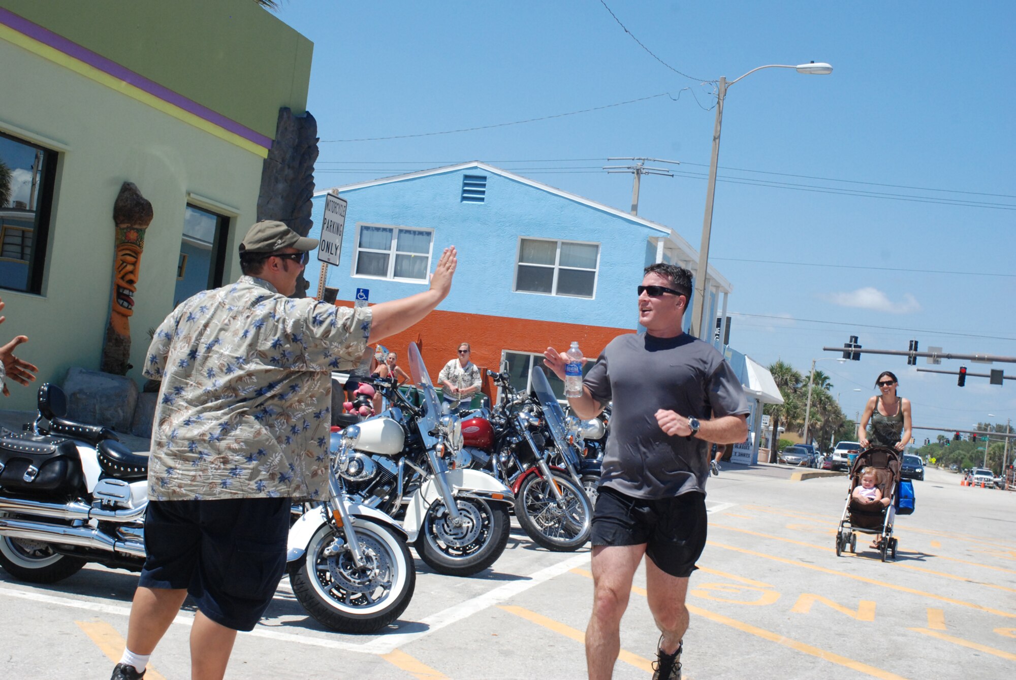 PATRICK AIR FORCE BASE, Fla. - Maj. Chad Senior, combat rescue officer and former Olympian, from the 920th Rescue Wing here, high-fives Mr. Darrell Hankins, pararescue resource advisor, in Cocoa Beach April 21, 2011 at the finale of an endurance race. The first part of the race pitted pararescuemen against each other in a two-mile swim across the Banana River which then led to the six-mile foot-race portion. The training was called a Monster Mash - a fun training day geared to build endurance and camaraderie among the Air Force Special Forces Airmen here. (U.S. Air Force photo/Staff Sgt. Leslie Forshaw)