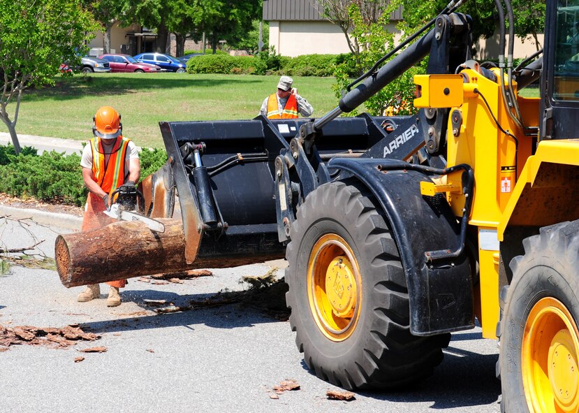 Airman 1st Class Bryan Whitford, 23rd Civil Engineer Squadron heavy equipment operator, uses a chain saw to cut a tree that was blocking the road during a Hurricane Evacuation Exercise April 21 at Moody Air Force Base, Ga. Cutting the tree stump makes it easier for the loader truck operator to move the tree off the road. (U.S. Air Force photo/Senior Airman Stephanie Mancha)(RELEASED)
