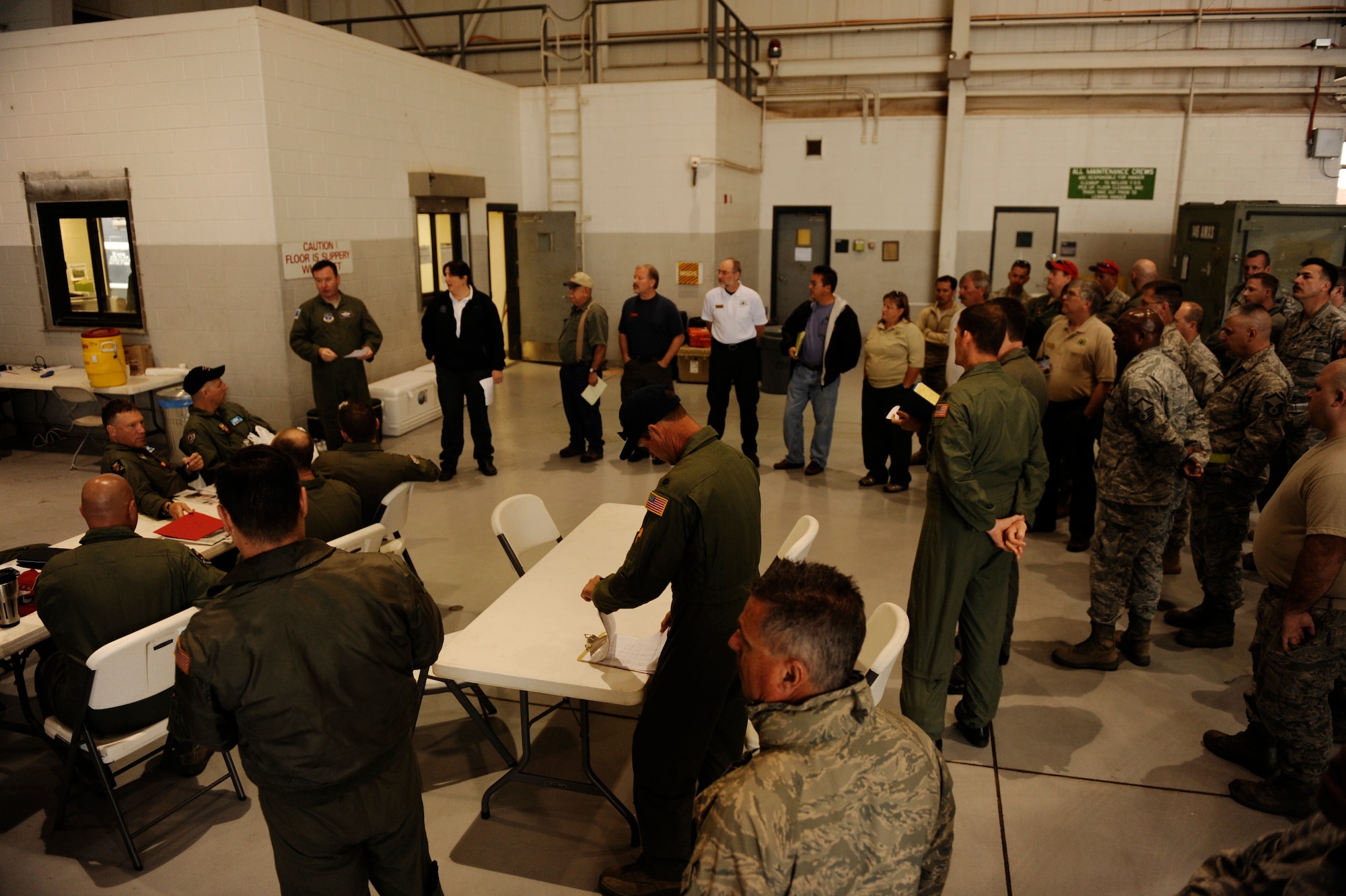 Airmen from California Air National Guard's 146th Airlift Wing, North Carolina Air National Guard's 145th Airlift Wing and Wyoming Air National Guard's 153rd Airlift Wing and members of the U.S. Department of Agriculture, Forestry Service conduct their morning briefing during firefighting operations at Dyess Air Force Base, Texas, April 21, 2011.  The Airmen maintain and operate the Modular Airborne Firefighting System(MAFFS) housed aboard a C-130 Hercules which is capable of dispensing 3,000 gallons of water or fire retardant in under 5 seconds.  The wildfires have spread across various parts of Texas and have burned more than 1,000 square miles of land.  (U.S. Air Force Photo/Staff Sgt. Eric Harris)