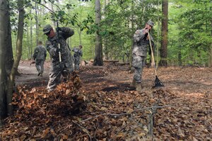 Pfc. Roy Peters, 567th ICTC, 24th Trans.Bn., 7th Sust.Bde., and Spc. Joshua Hanking, 97th Transportation Battalion, 10th Transportation Battalion, 7th Sust. Bde., clear the trail of leaves during the clean-up. (U.S. Air Force Photo/Lyna Tucker)