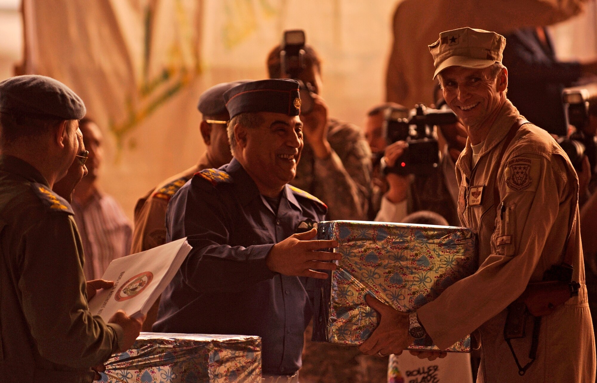 NEW AL-MUTHANA AIR BASE, Iraq -- Brig. Gen. Anthony Rock, Iraq Training and Advisory Mission - Air director, accepts a gift of appreciation from Iraqi air force leaders during the Iraqi air force's 80th anniversary celebration here April 21. More than 1,000 Airmen, Soldiers and contractors advise, train and assist their Iraqi partners at six major locations throughout Iraq in an effort to bolster the nation's capacity to provide internal security and defend against external threats. (U.S. Air Force/Tech. Sgt. Jason Lake)