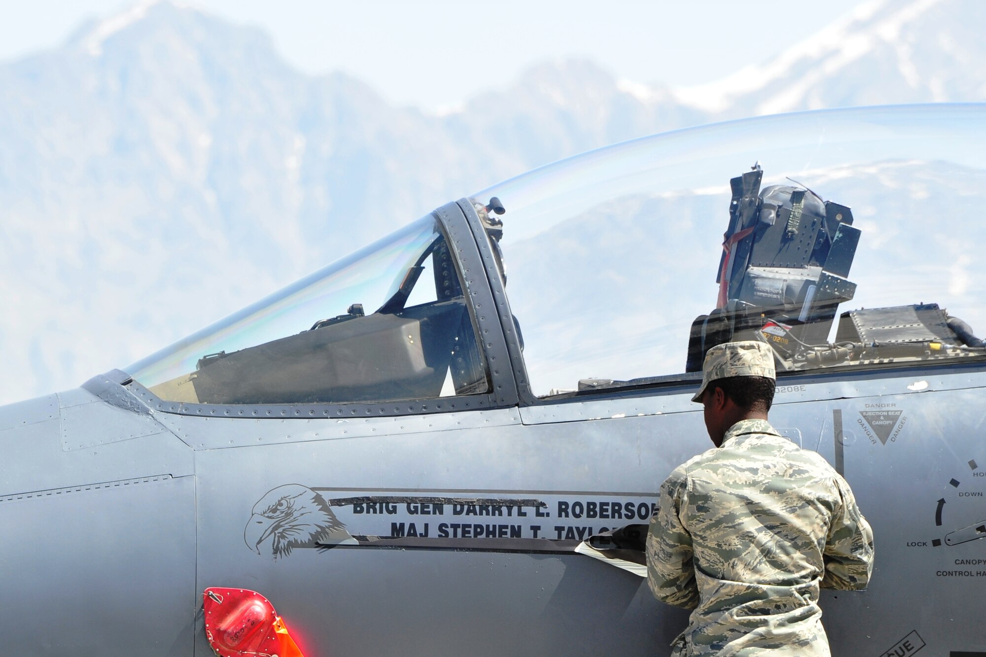 Airman 1st Class Andrew Brown, 455th Expeditionary Aircraft Maintenance Squadron, unveils Brig. Gen. Darryl Roberson's name on a Bagram F-15E Strike Eagle.  General Roberson assumed command of the 455th Air Expeditionary Wing during a ceremony at Bagram Airfield, Afghanistan, April 22, 2011.  (U.S. Air Force photo by Capt. Erick Saks)