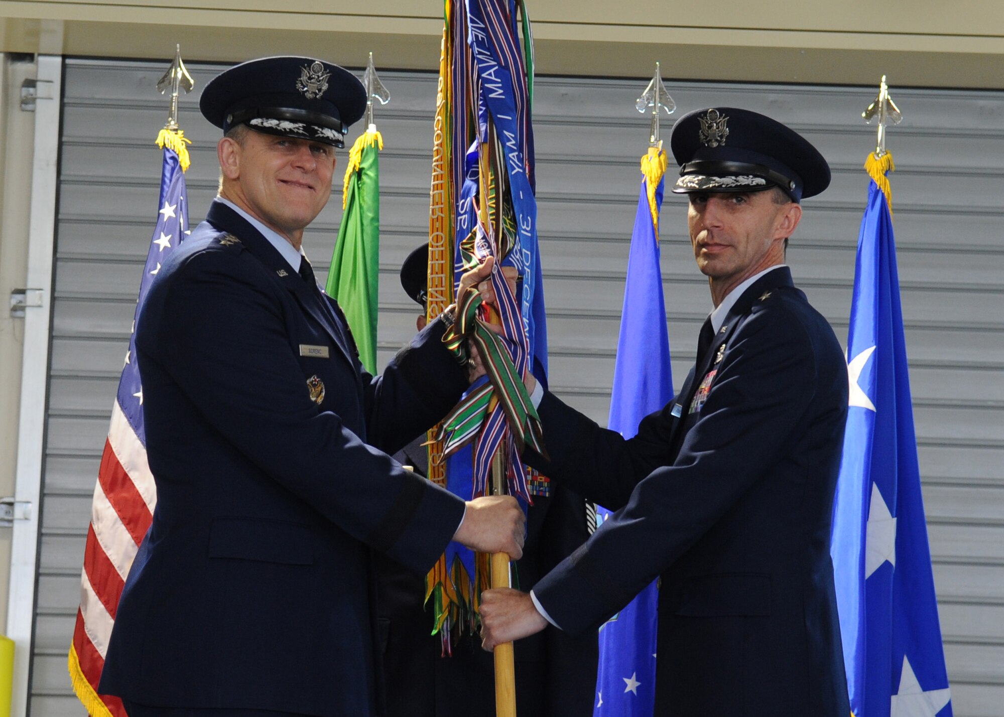 Lt. Gen. Frank Gorenc, 3rd Air Force commander, passes the 31st Fighter Wing guidon to Brig. Gen. Scott J. Zobrist as the new wing commander during the change of command ceremony April 22 at Aviano Air Base, Italy. General Zobrist was the 388th Fighter Wing commander at Hill Air Force Base, Utah. (U.S. Air Force photo/ Staff Sgt. Nadine Y. Barclay)